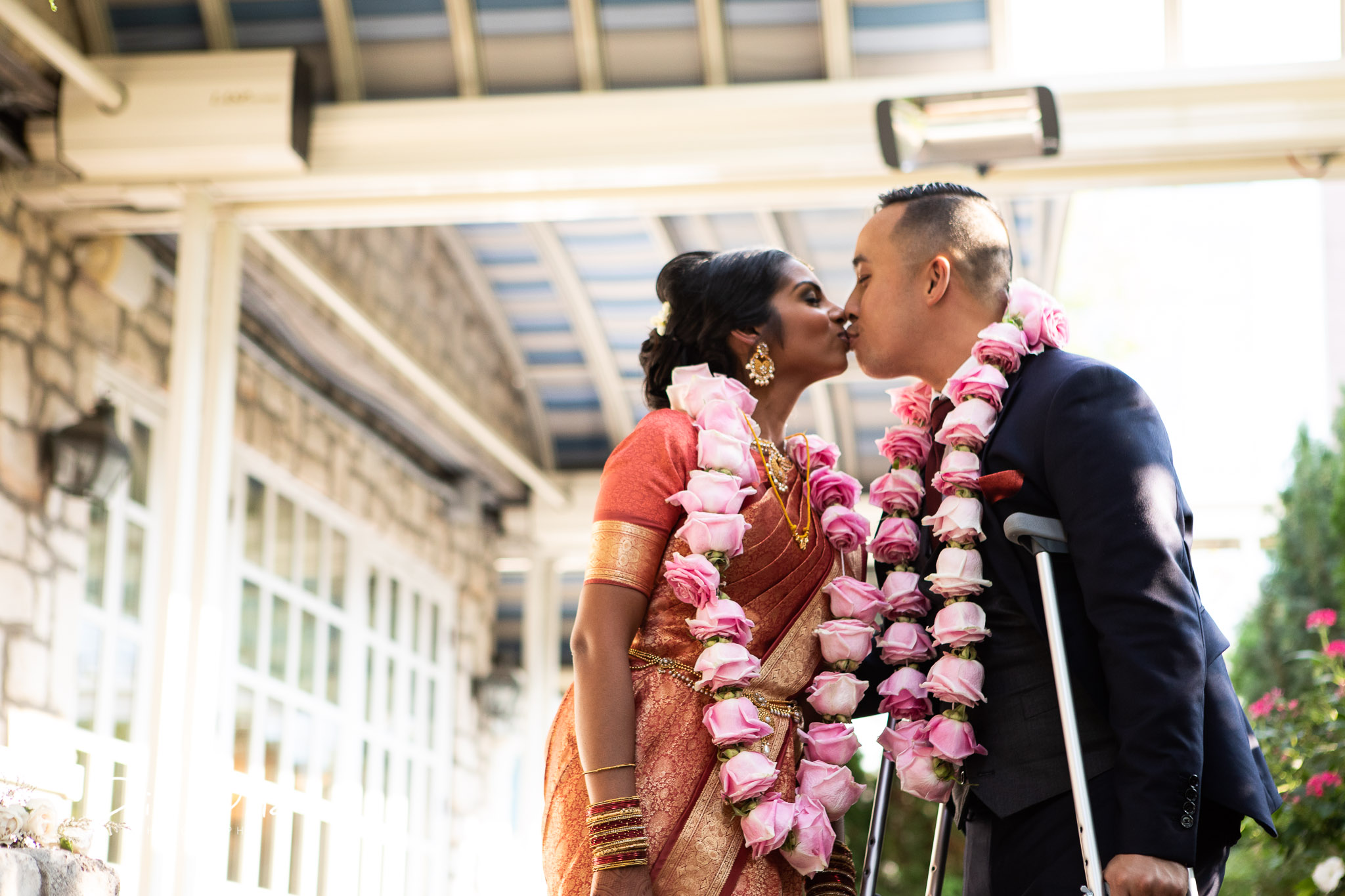 first kiss with groom standing using crutches.jpg