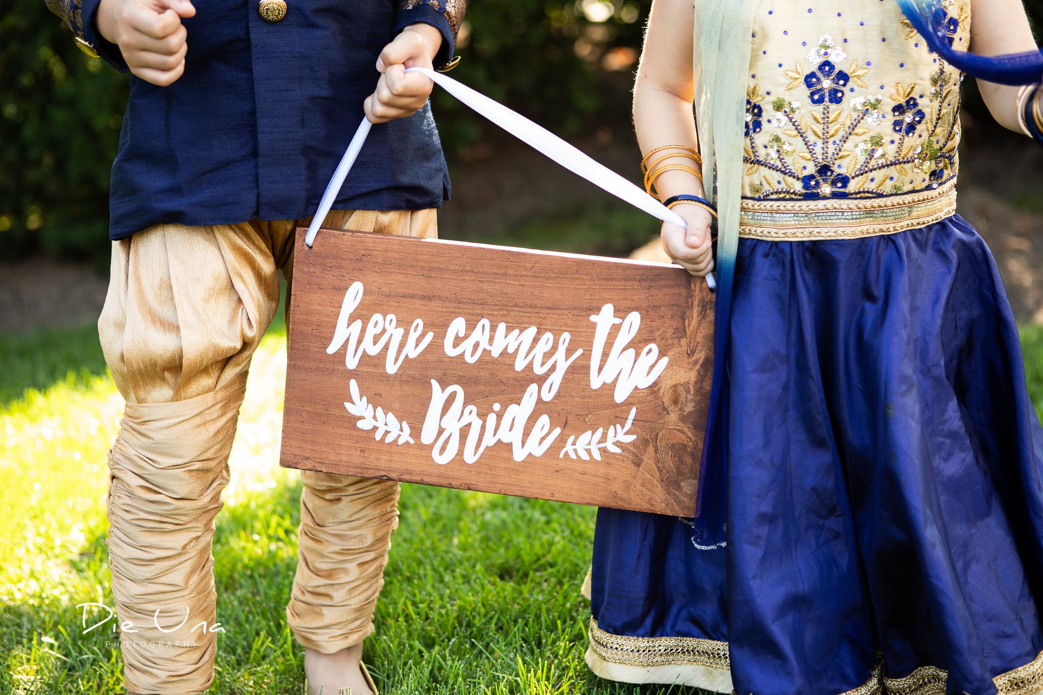 here comes the bride sign being held by flower girl and ringbearer in Hindu wedding.jpg