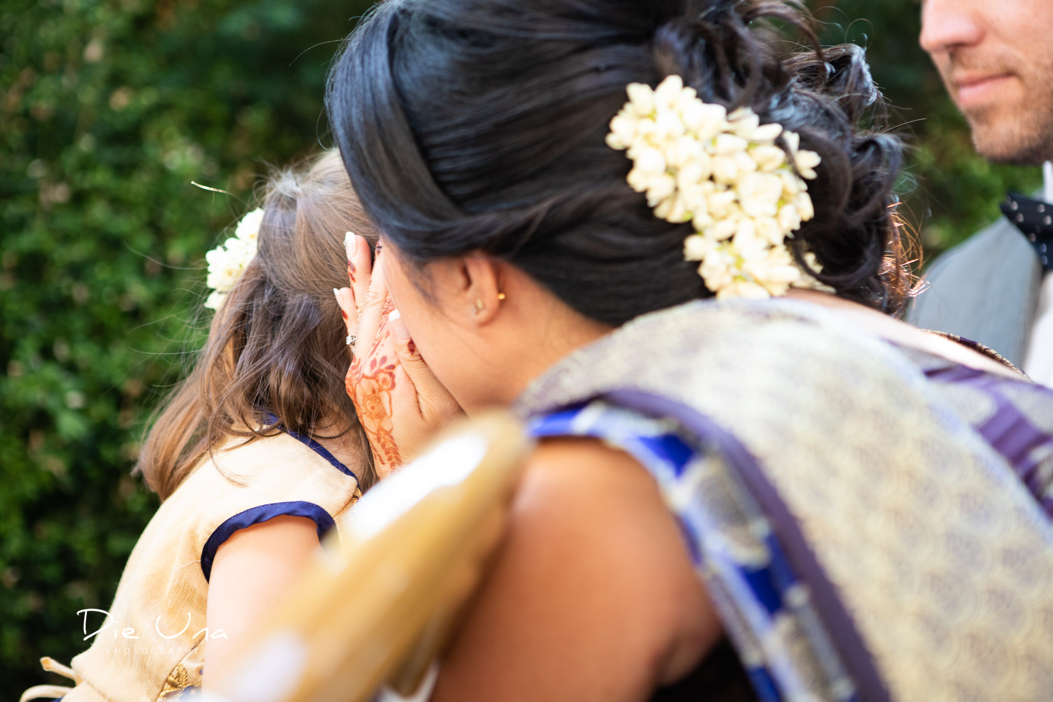 mom whispering to young duaghter during wedding ceremony.jpg