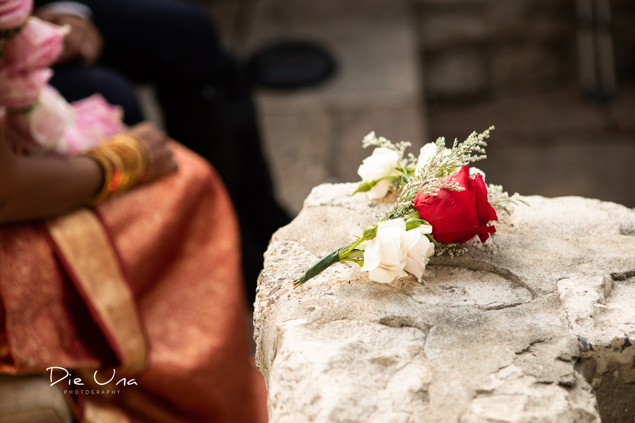 small hand held wedding bouquet resting on rock ledge during wedding ceremony.jpg