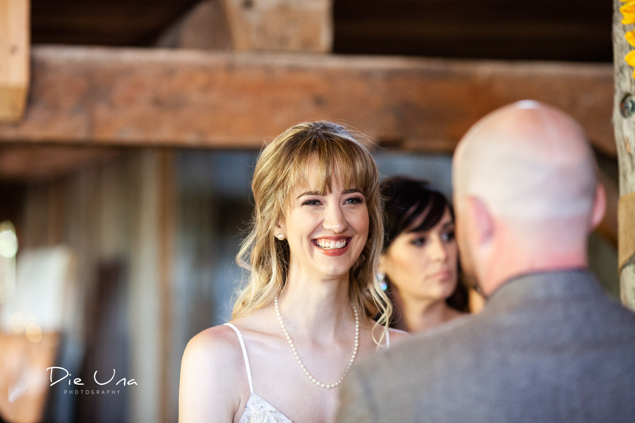 bride smiling at groom during wedding ceremony in a barn in southern ontario kitchener wedding photographer.jpg