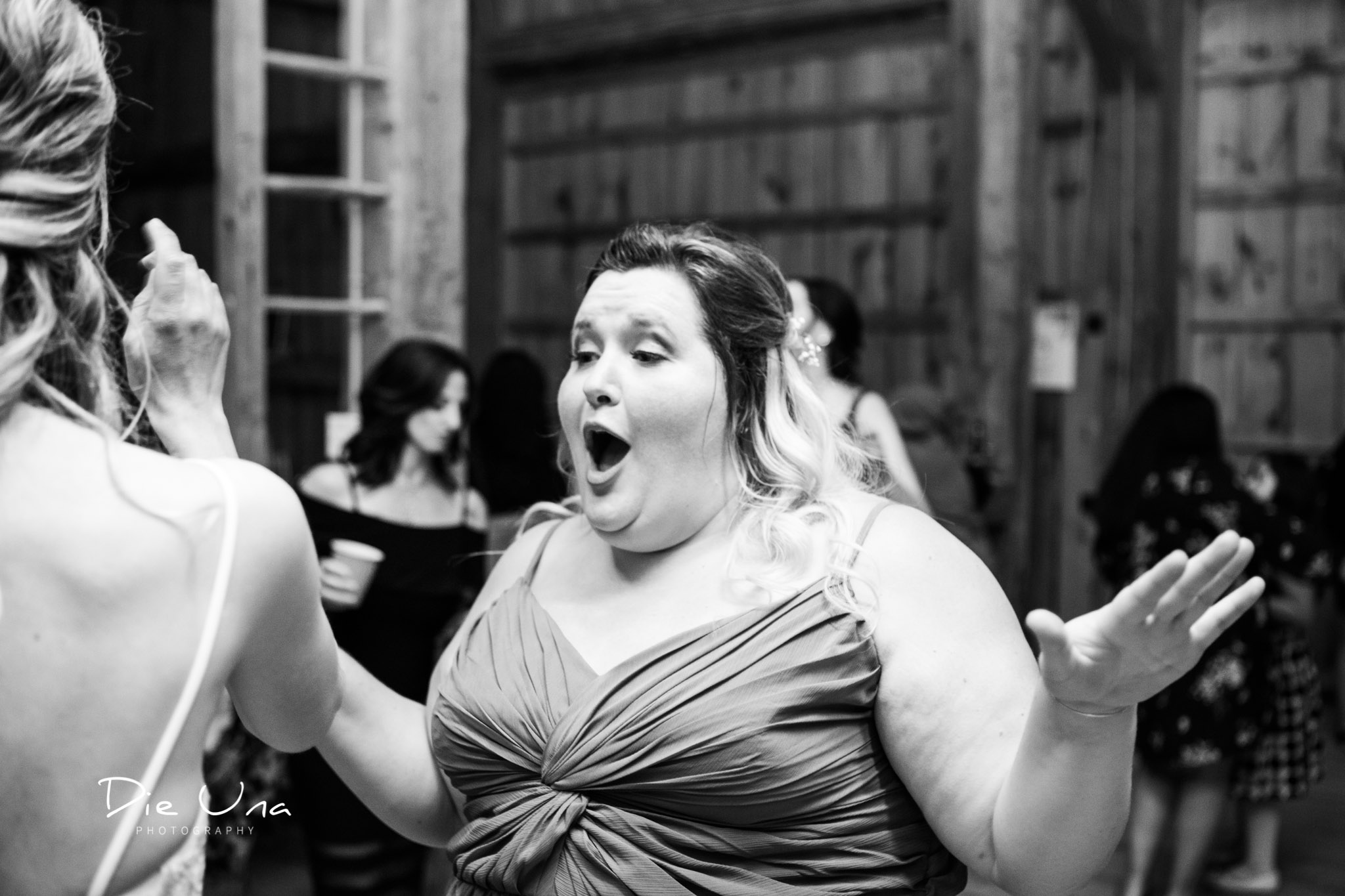 bridesmaid dancing during wedding dance reception black and white candid photography.jpg