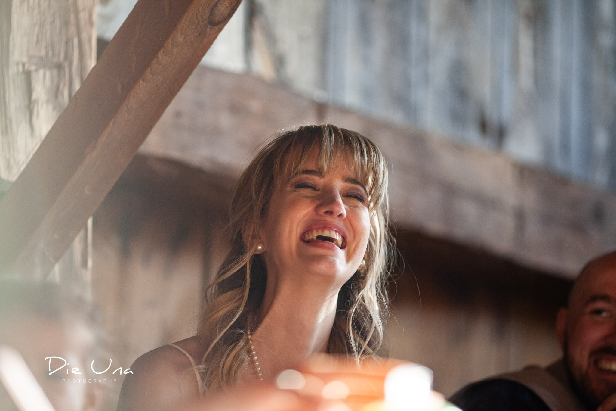 close up of bride laughing at a wedding speech during wedding reception.jpg