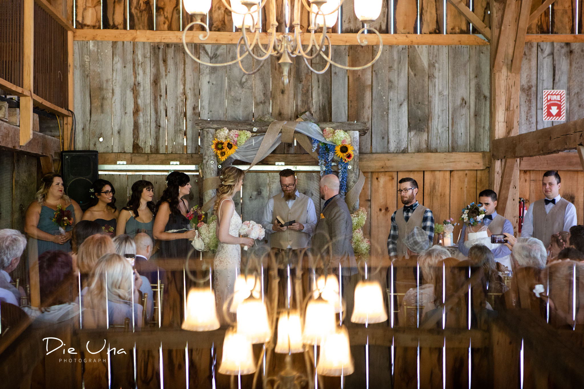 entire wedding party standing at the front of barn for wedding ceremony.jpg