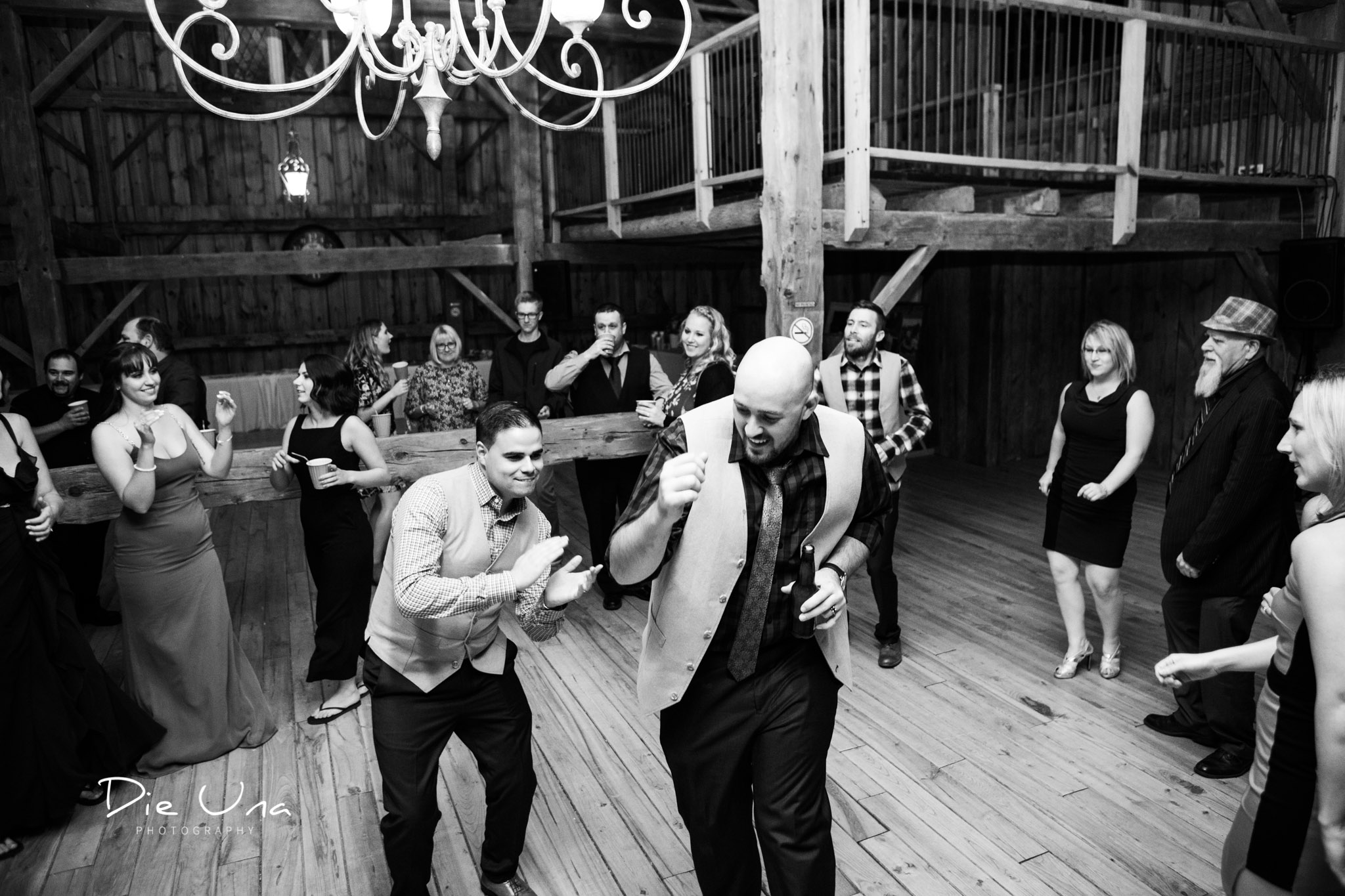 groom dancing in a circle of wedding guests in barn wedding reception.jpg