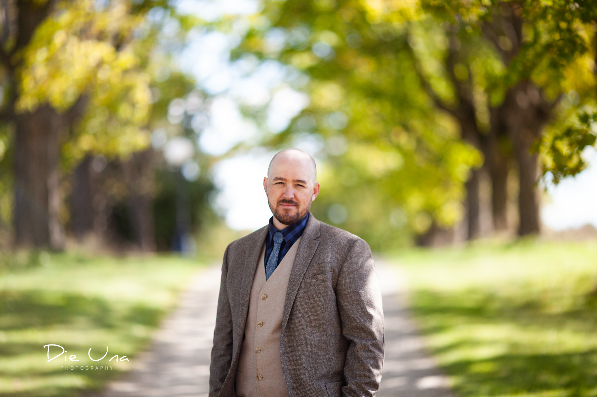 groom portrait on tree lined driveway for wedding photography.jpg
