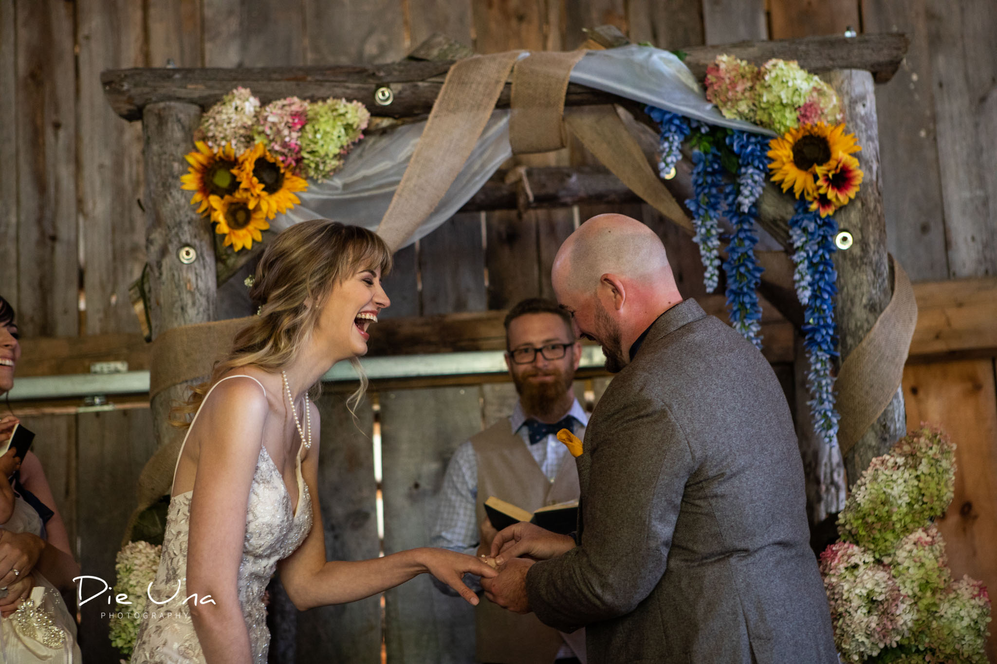 groom putting ring on brides hand bride laughing.jpg
