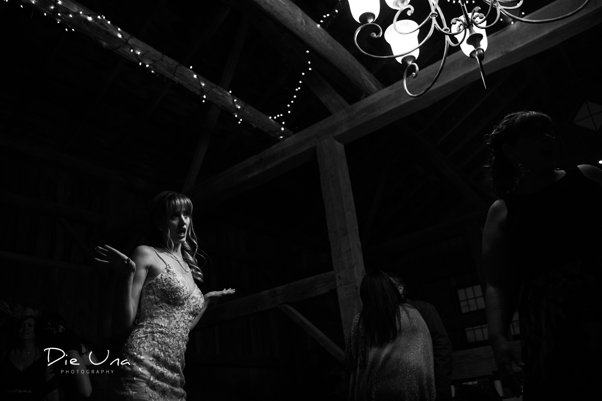 high contrast black and white photography bride dancing with chandelier in frame.jpg