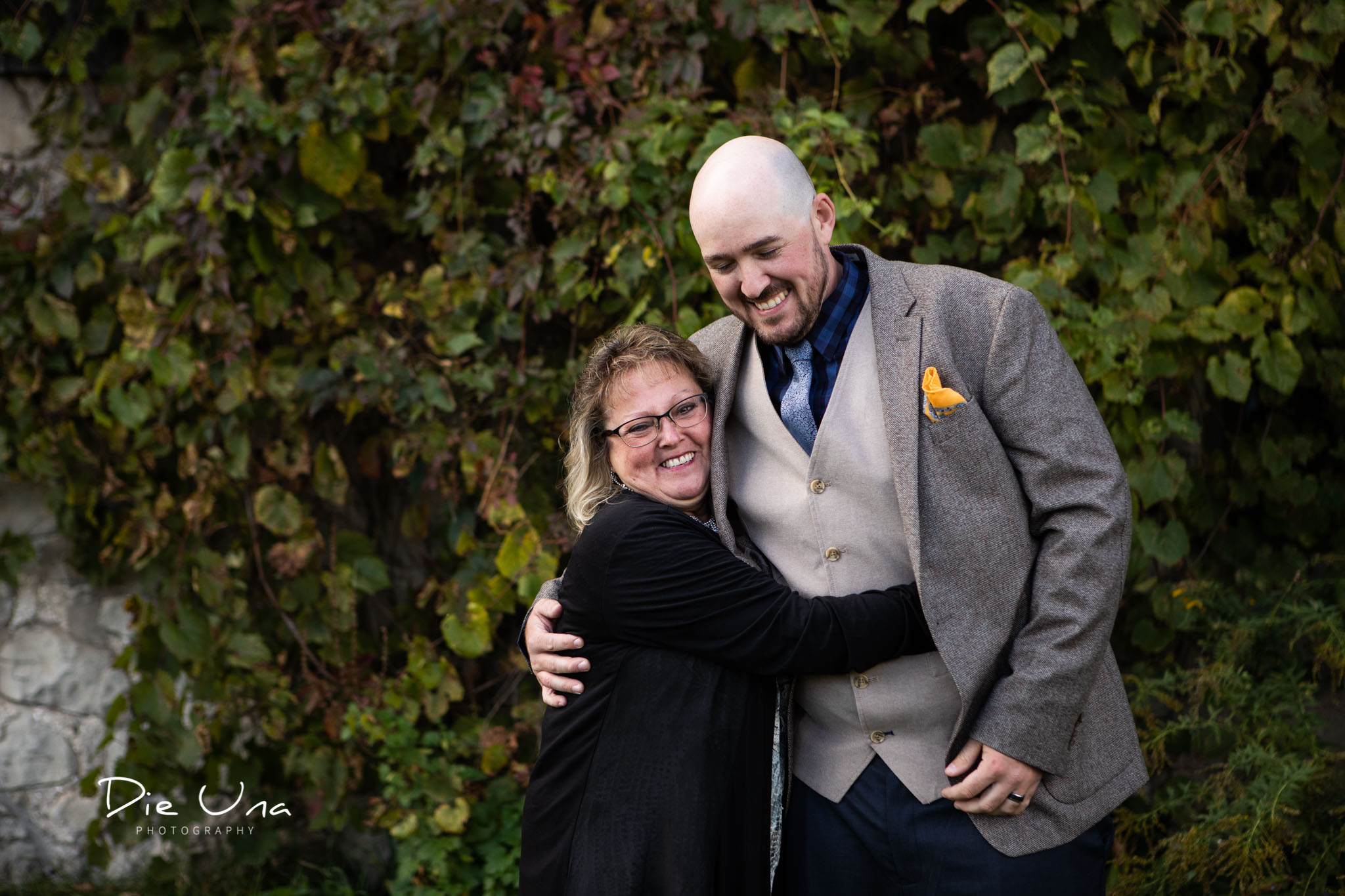 mother of the groom giving groom a big hug after the wedding in front of a barn.jpg