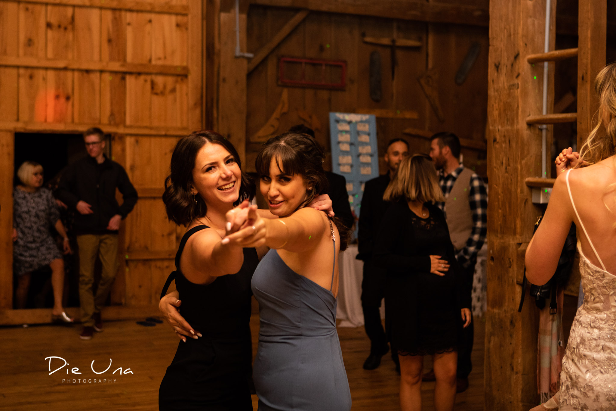 two female wedding guests dancing spiritedly during barn dance reception kitchener wedding photographer.jpg