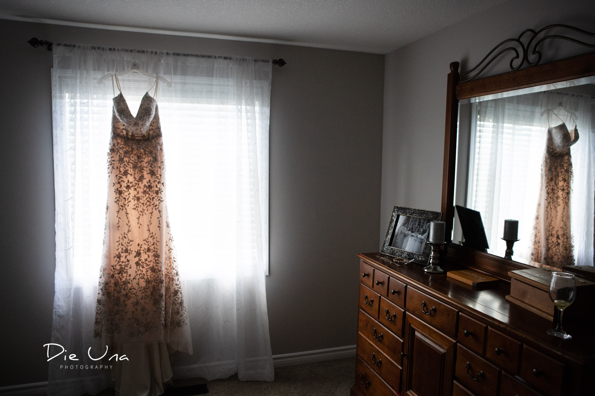 wedding dress hanging in window and reflected in dresser mirror.jpg