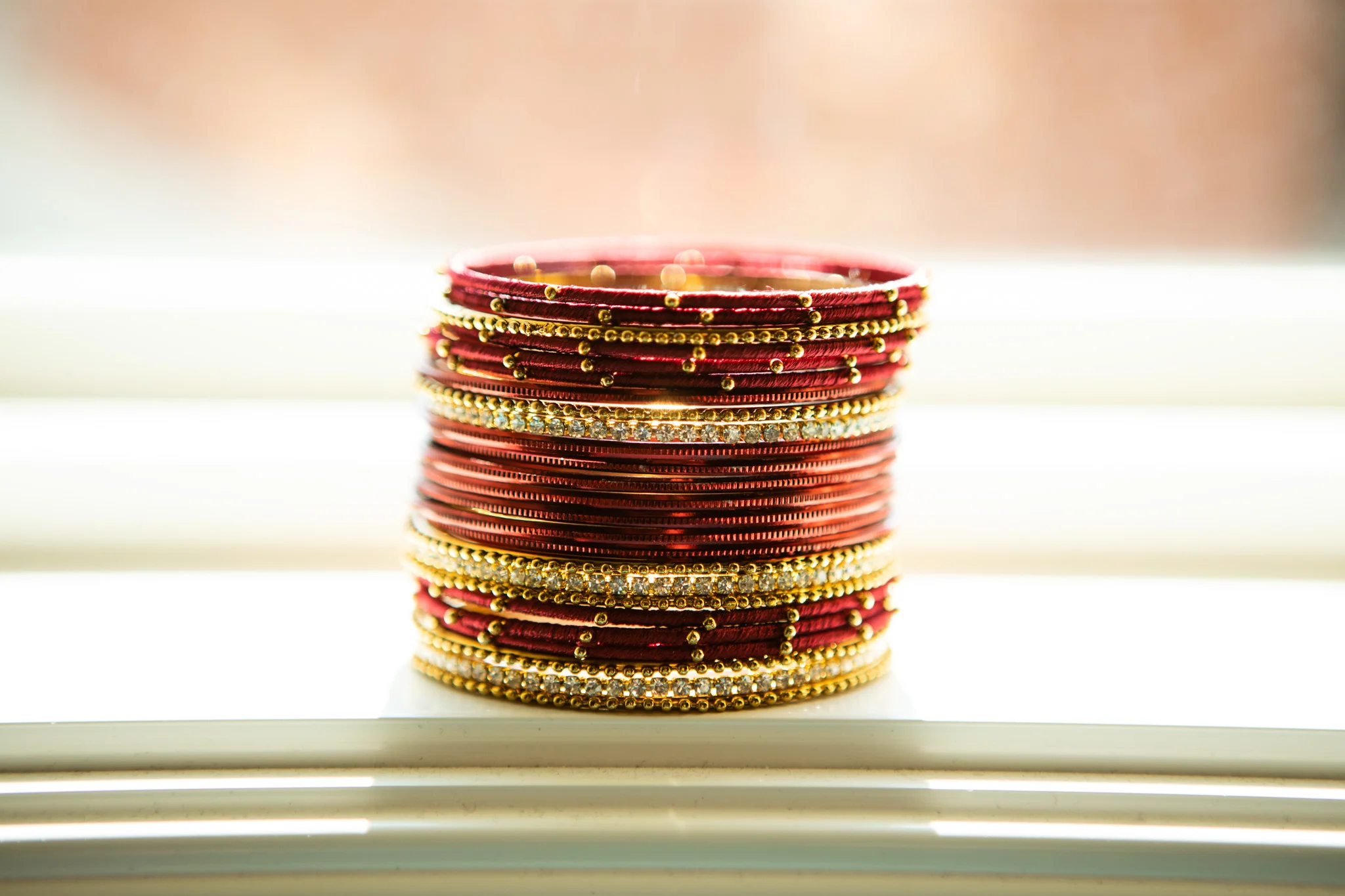 sri lankan wedding red and gold bracelets stacked in window.jpg
