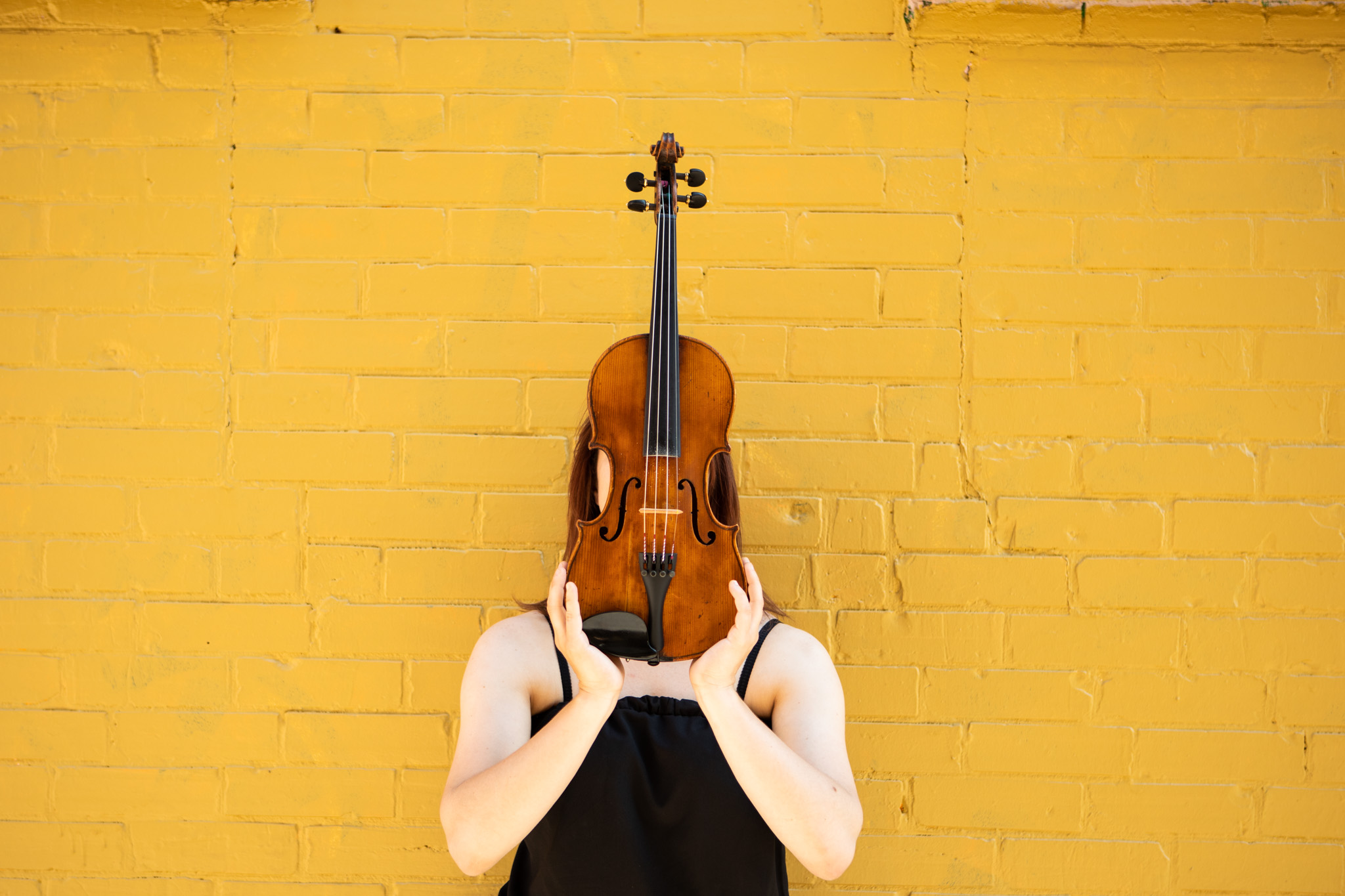 musician photographer Alison on a yellow brick wall with violin.jpg