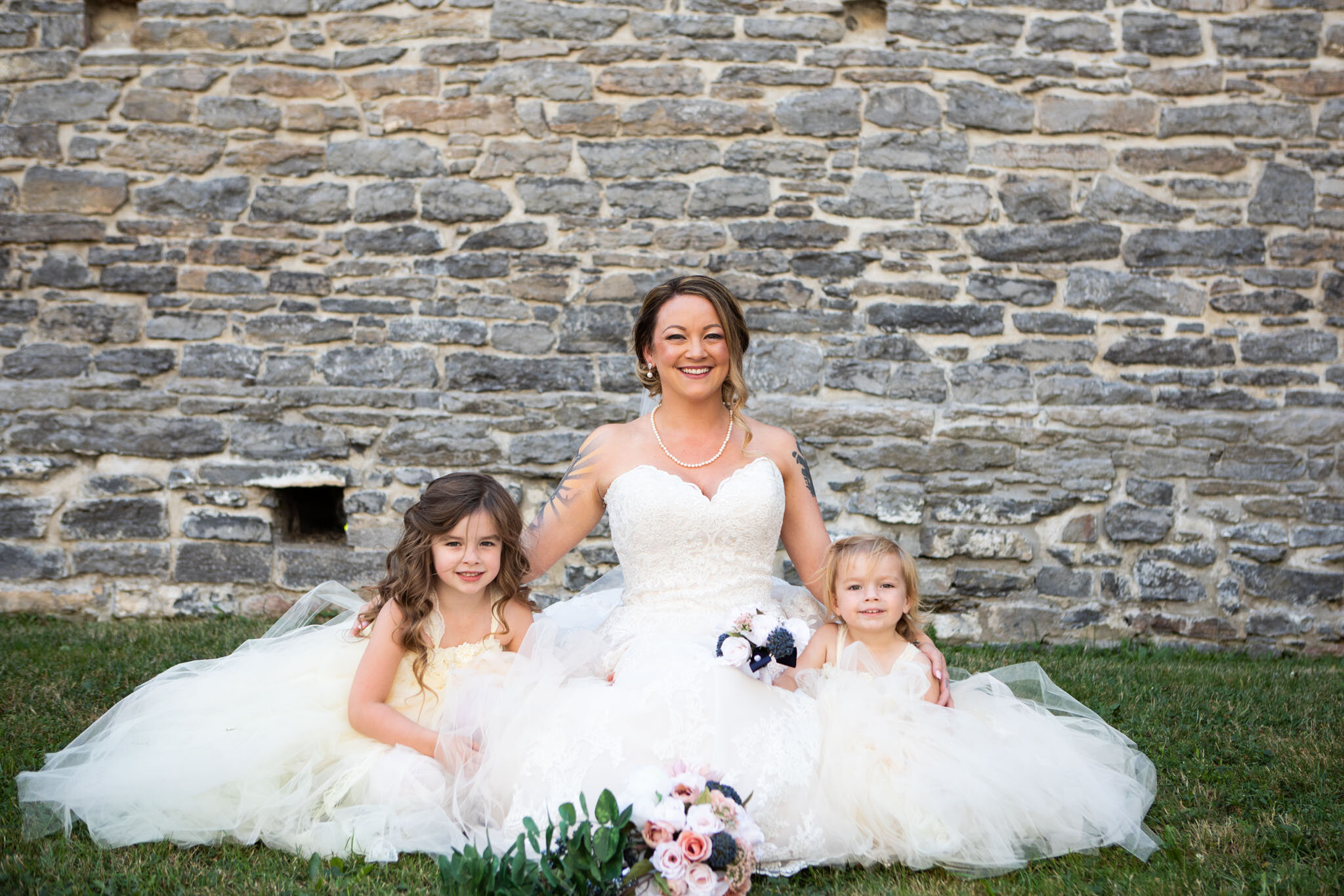 bride sitting with flower girls in side the ruins of St Raphael's Church.jpg