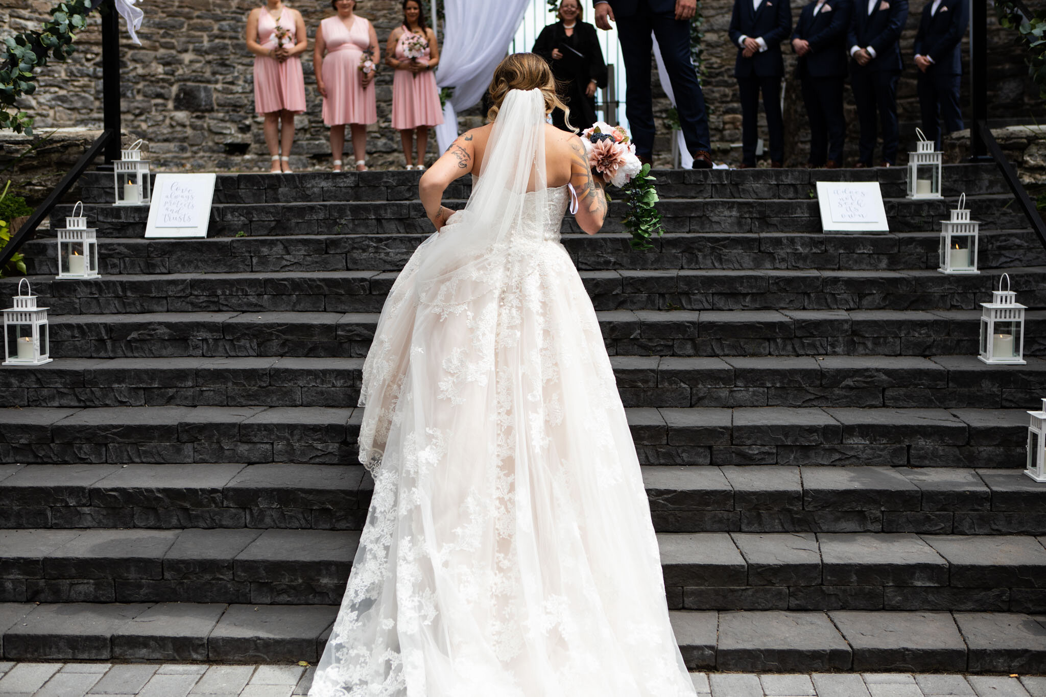 bride walking up the steps to the alter at St Raphael's Ruins.jpg