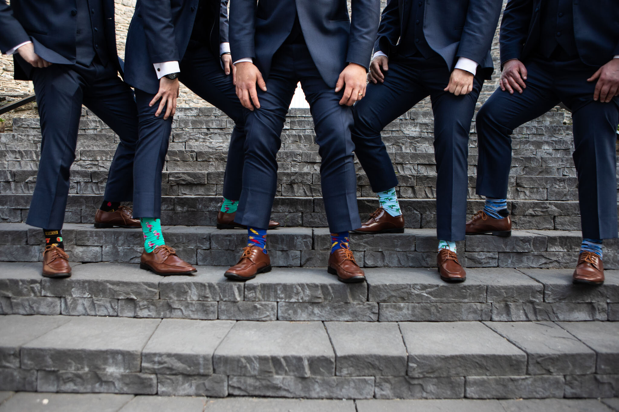 groomsmen showing off their fancy socks on the steps in St Raphael's Ruins.jpg