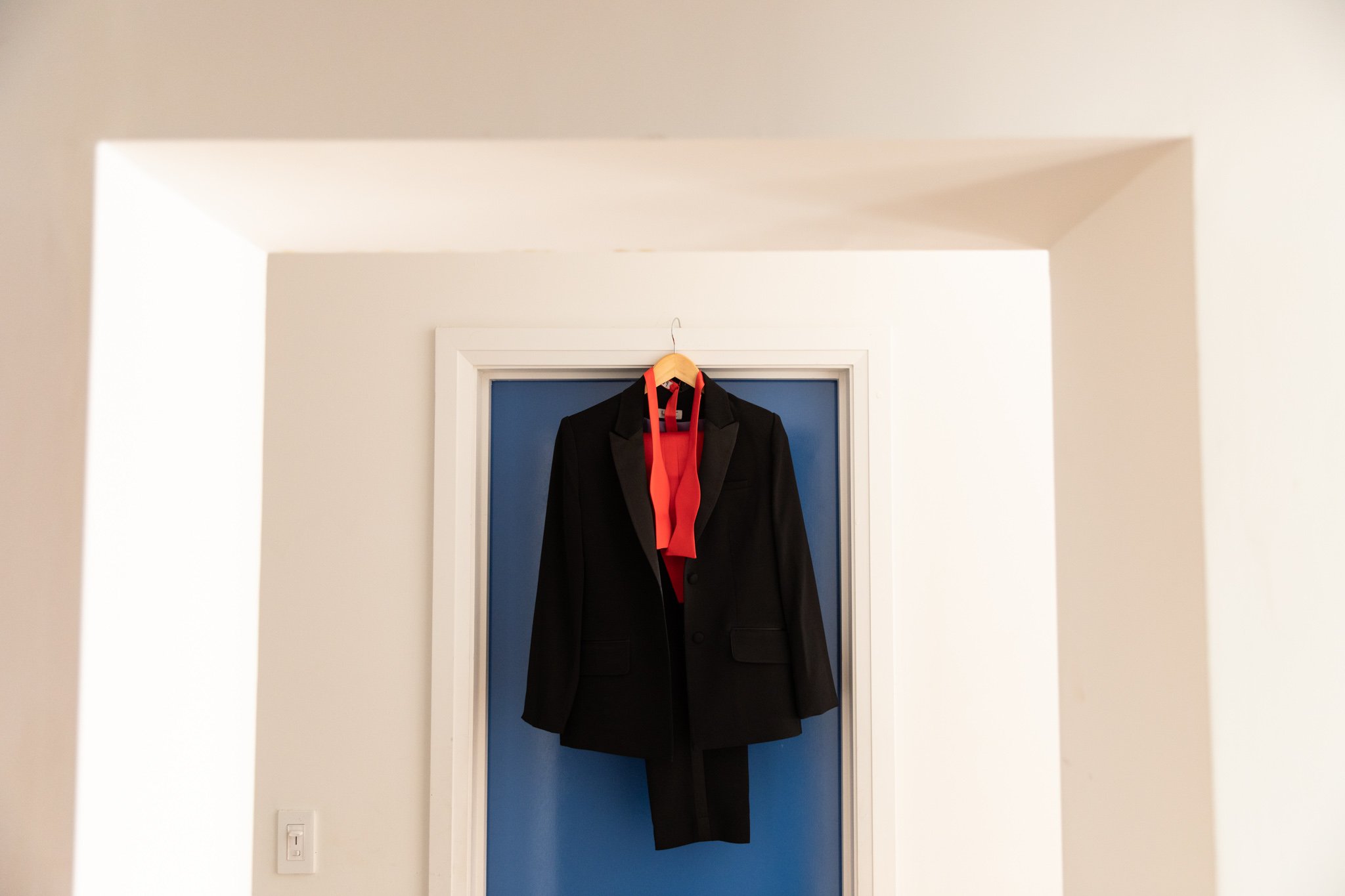 bride's suit double framed by a blue door and wall in the Walper Hotel Kitchener.jpg