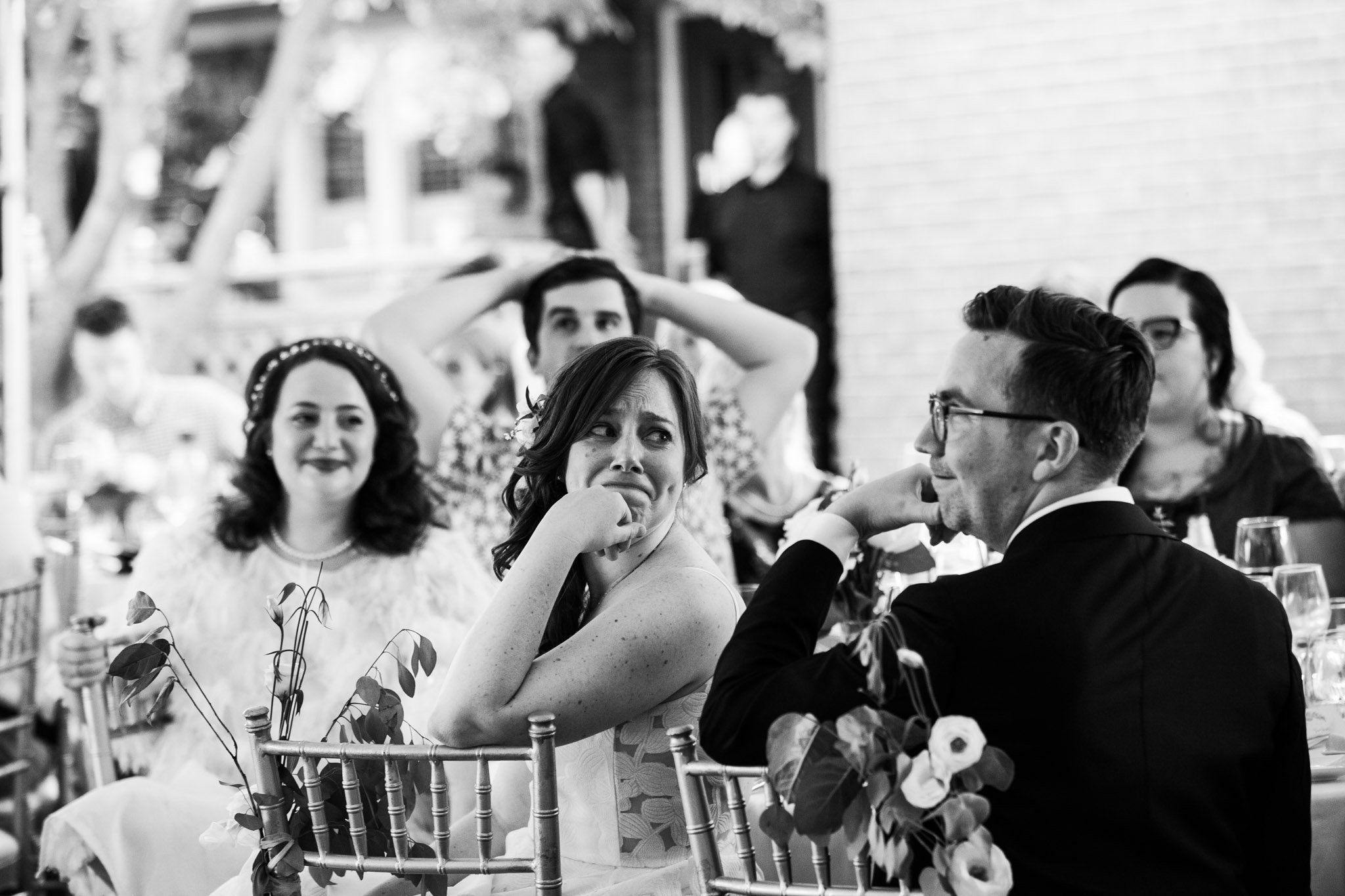 bride looking emotional at groom during speeches- black and white wedding photography.jpg