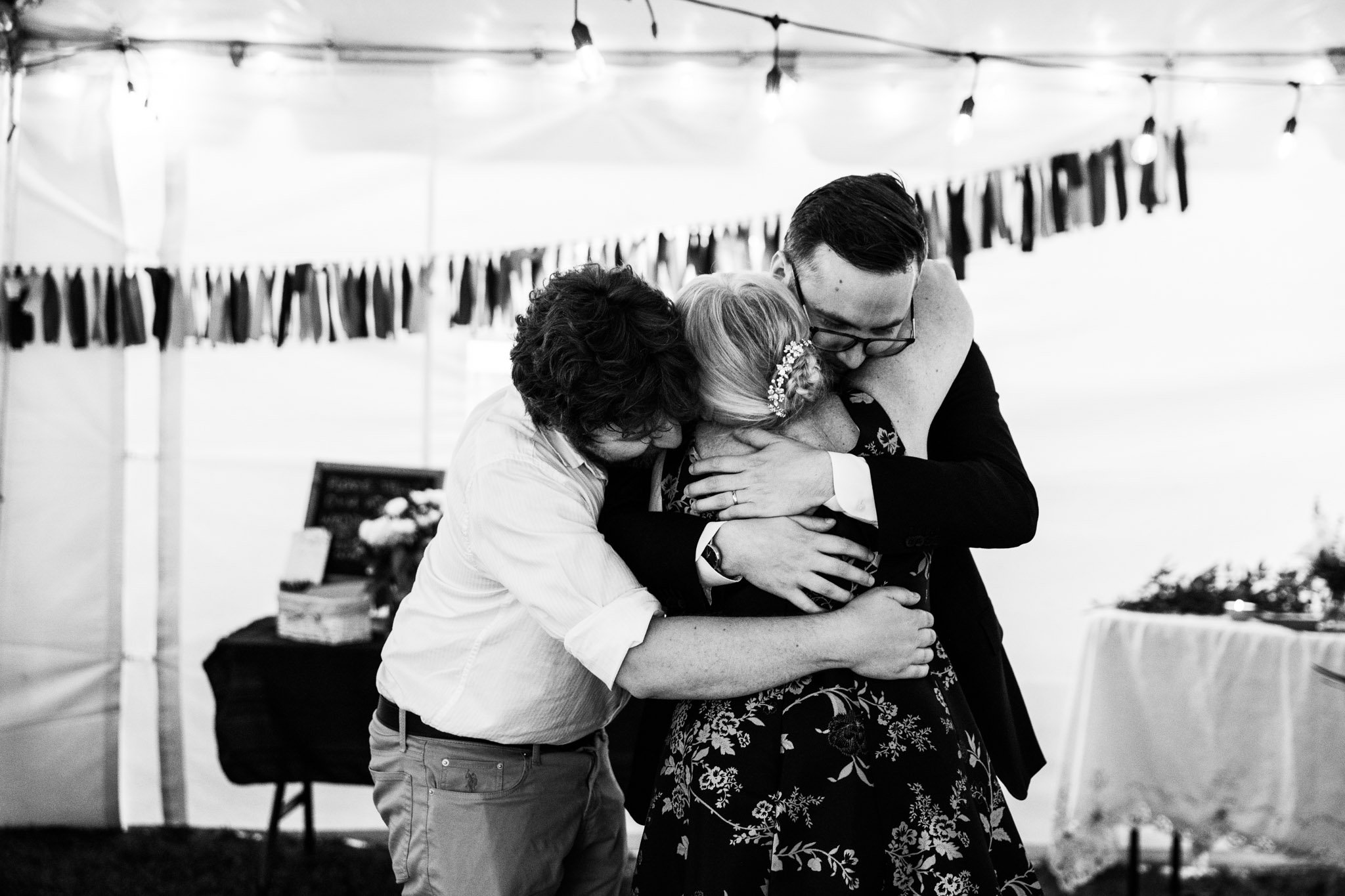 mother of the groom getting hugged by her kids - black and white wedding photography.jpg