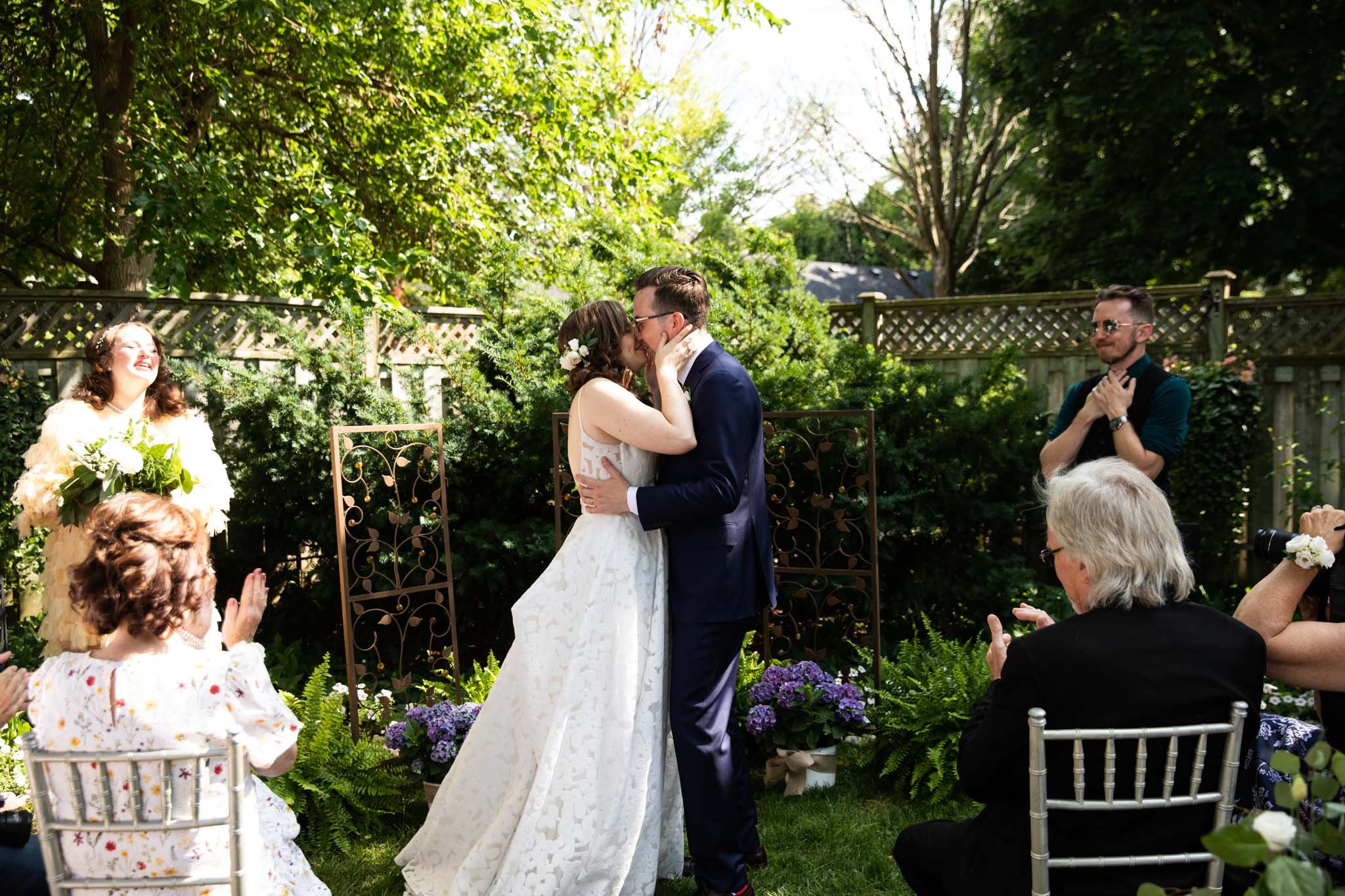 wide shot of bride and groom first kiss backyard wedding.jpg