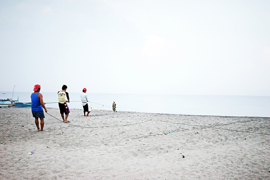It takes hours to reel in the nets. Passersby who want to help, are rewarded with a share of the fish.