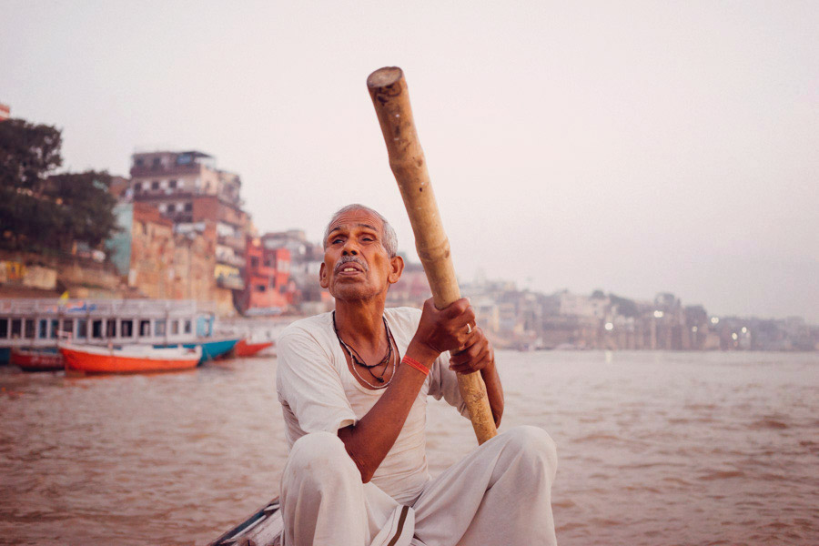  Steering the row boat along the Ganges. There are 84 ghats along the river, 2 of which are dedicated to cremation. Here we are on our way to visiting both.&nbsp; 