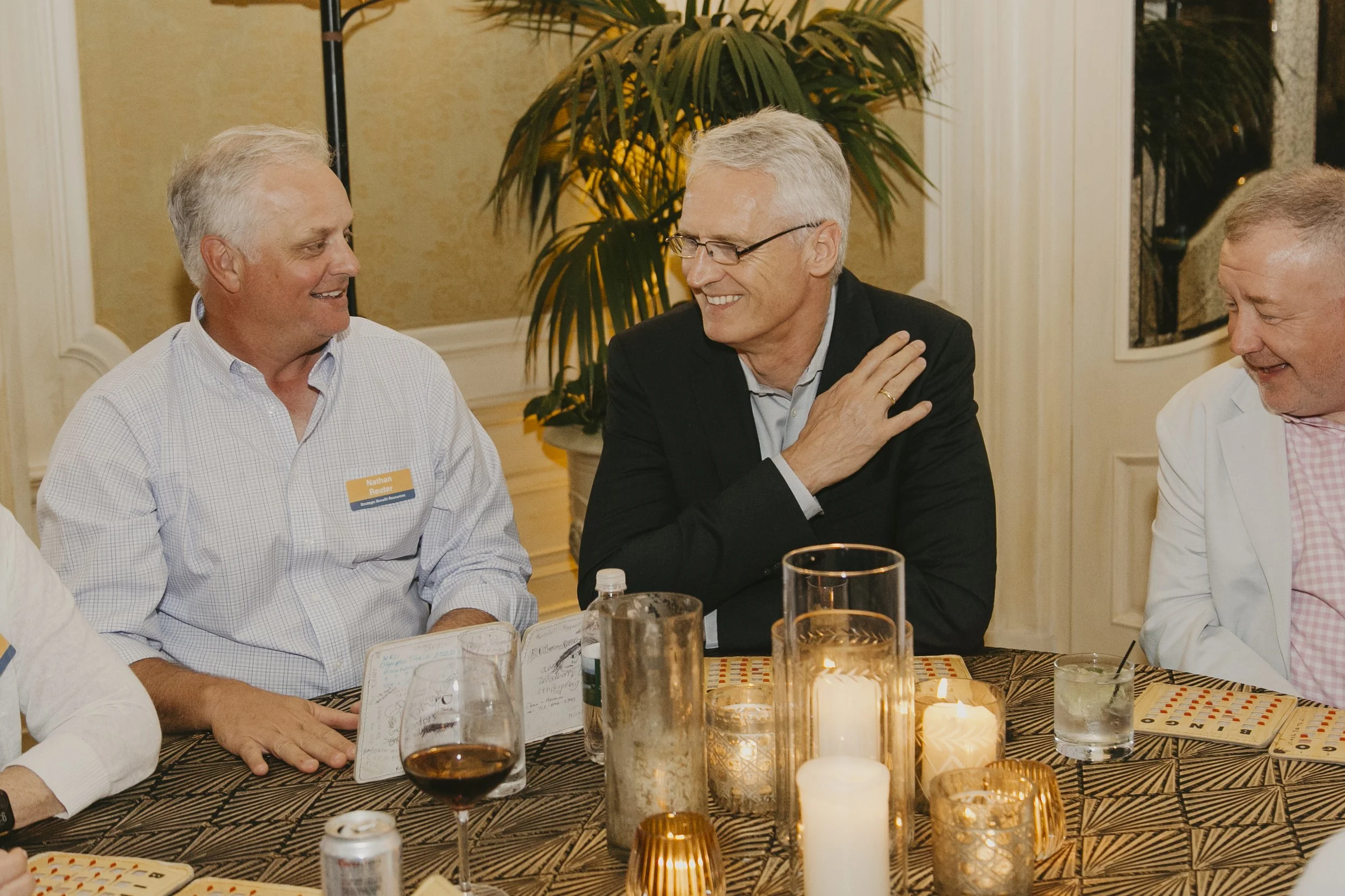 Conference guests laughing over a candlelit dinner at the Swiss Re producer conference at Sea Island