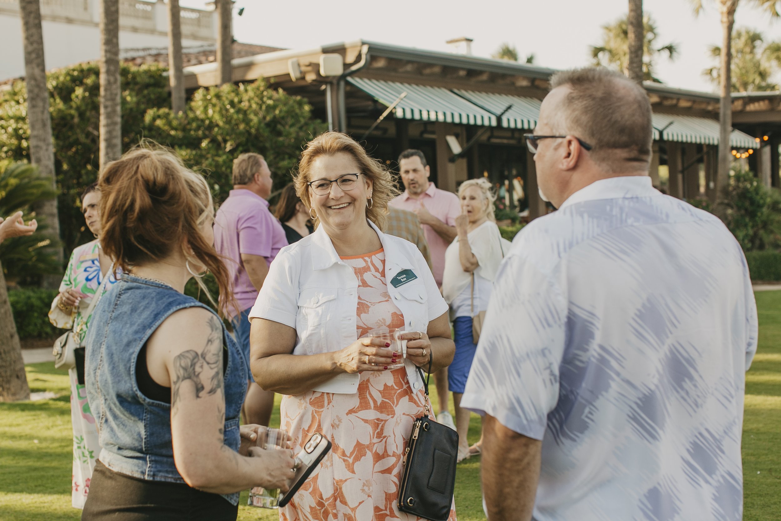 Conference attendees mingling on the lawn at a beach club reception at Sea Island Resort