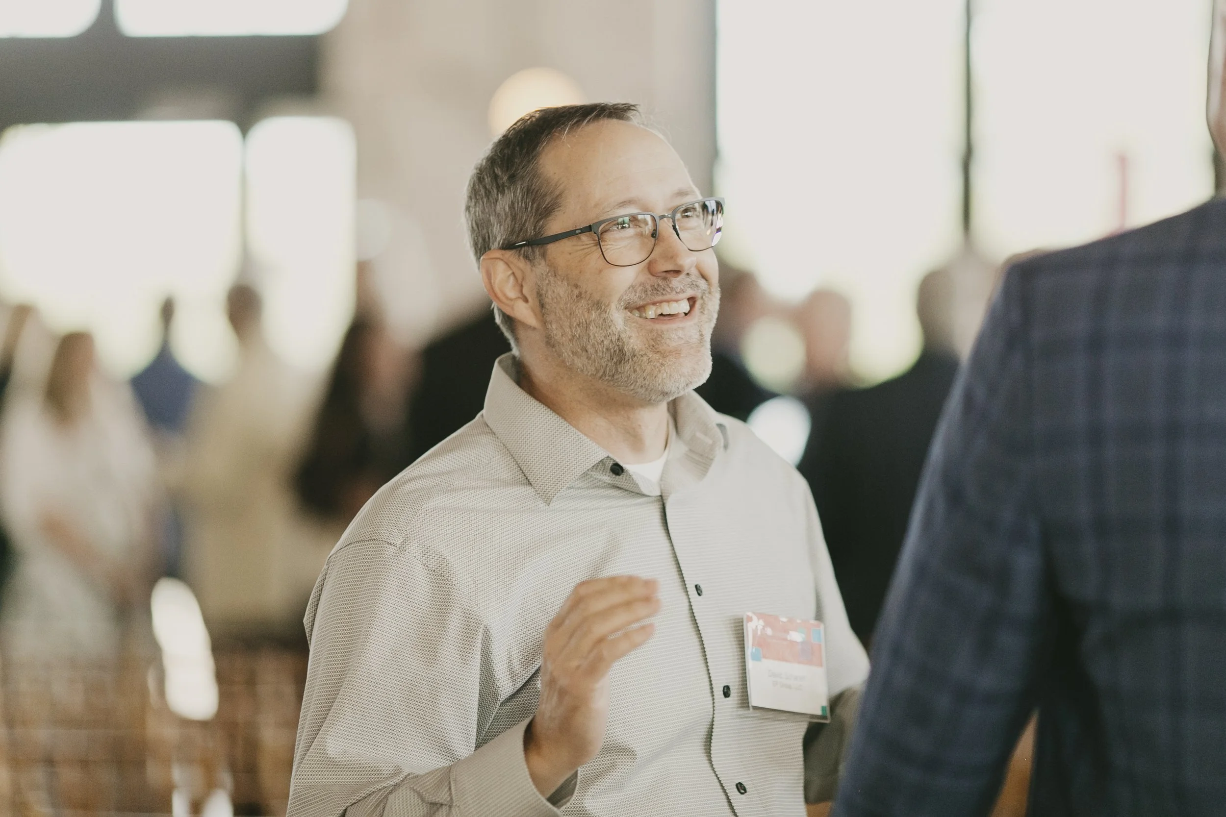 Guest laughing mid conversation during the networking hour at a corporate speaker event
