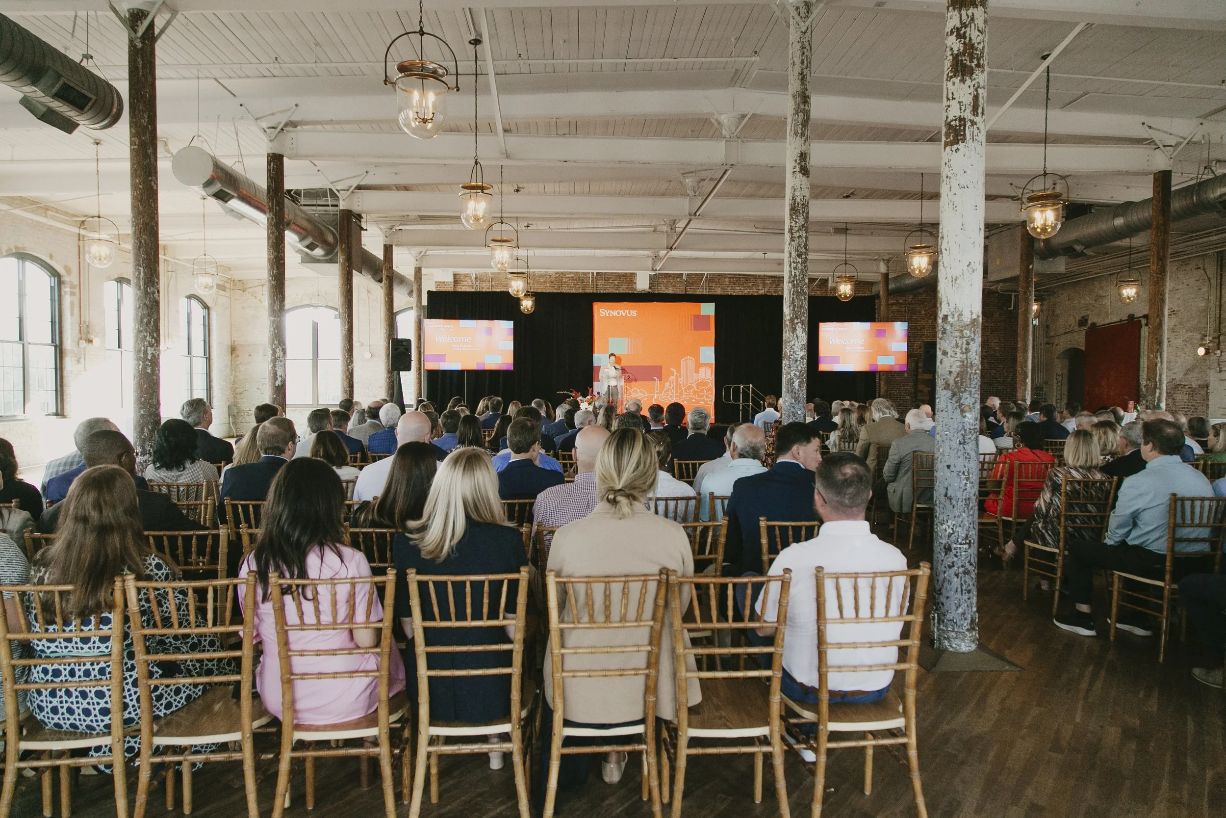 Wide view of a full room facing the keynote stage at the Synovus Journeys to Inspire event