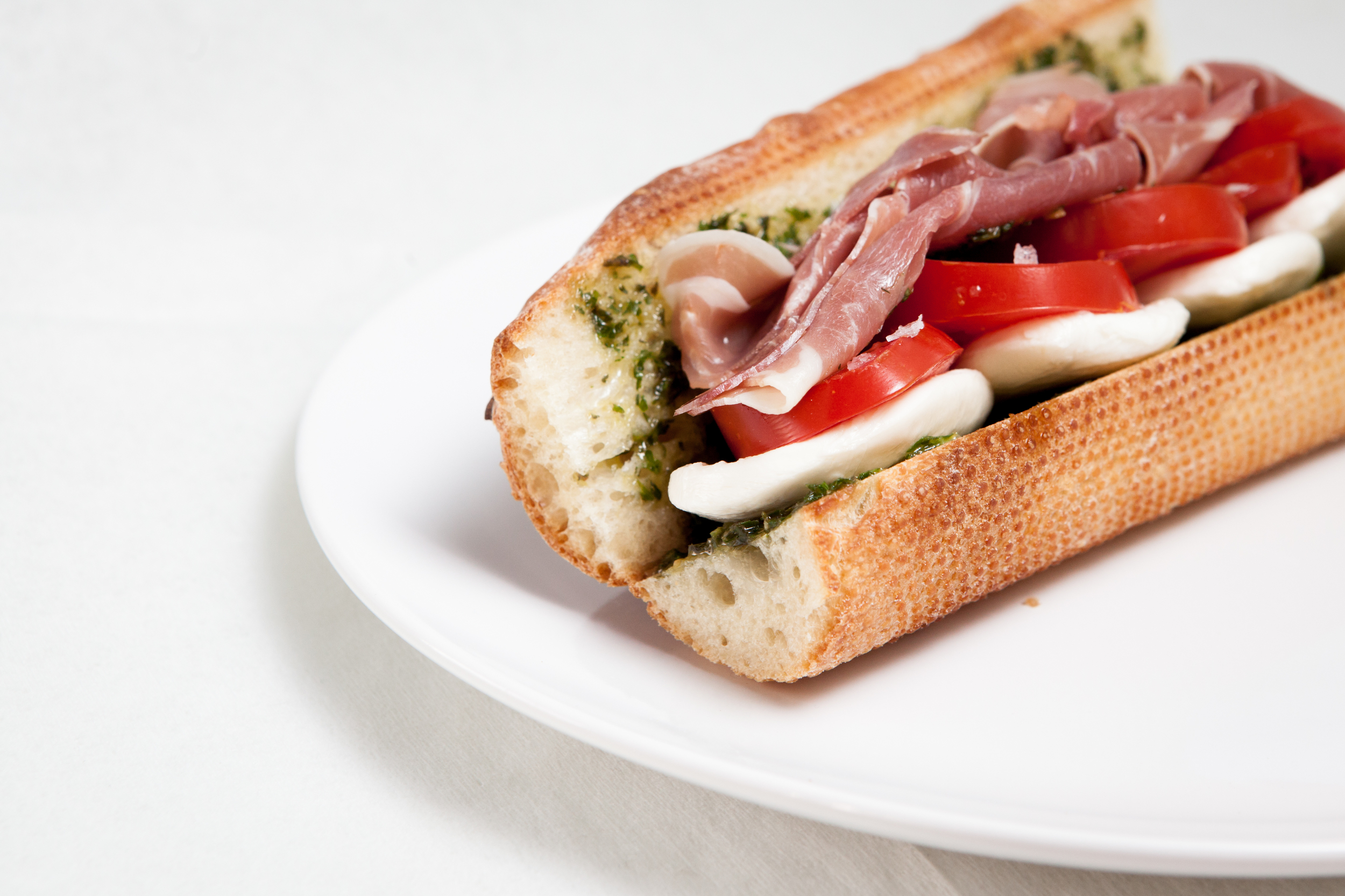 Proscuitto Sandwich- $9.95 Sliced bocconcini, tomato, prosciutto & house-made pesto on a baguette