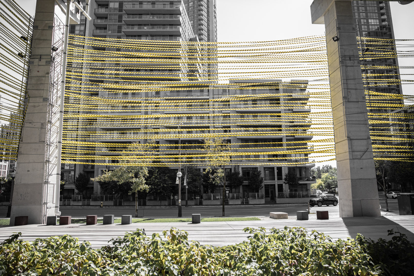   The Project   In “Hoarding,” hazard tape—a material typically used to keep people away from spaces under construction—will wrap a series of “bents” that hold up the Gardiner Expressway. The searing neon-yellow of the tape will act as a vibrant beac