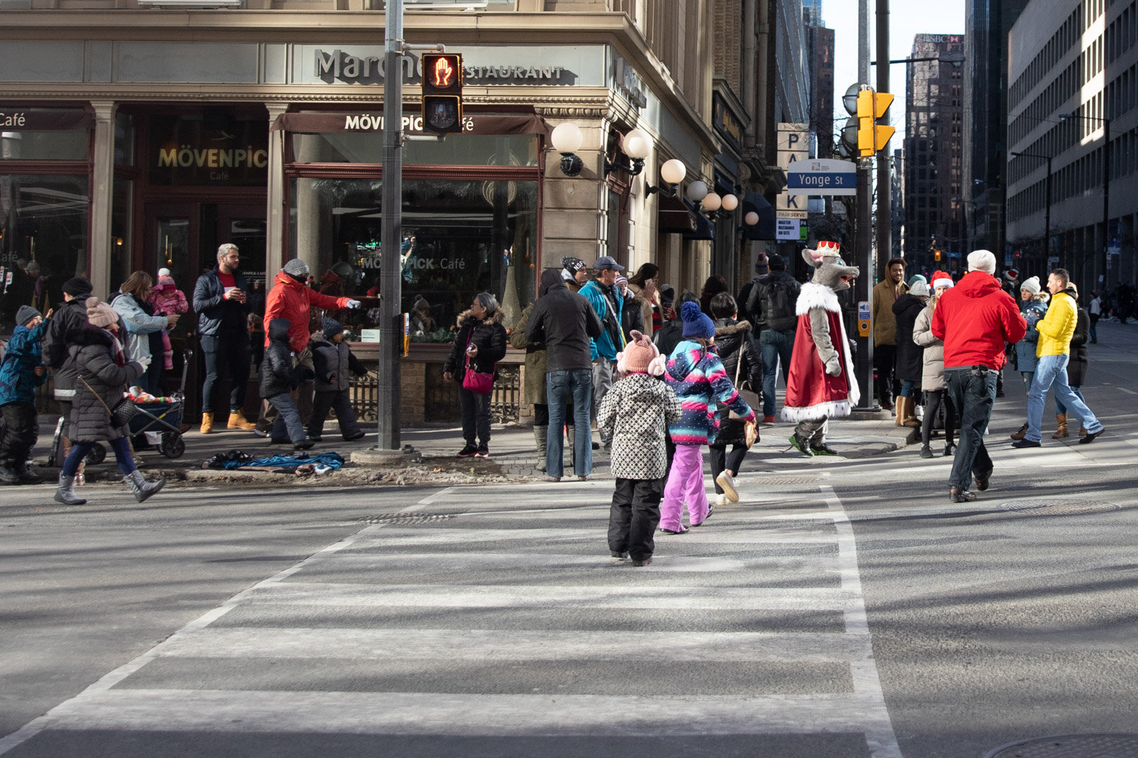  In this picture there are some kids running to get a picture with the Mouse King.   