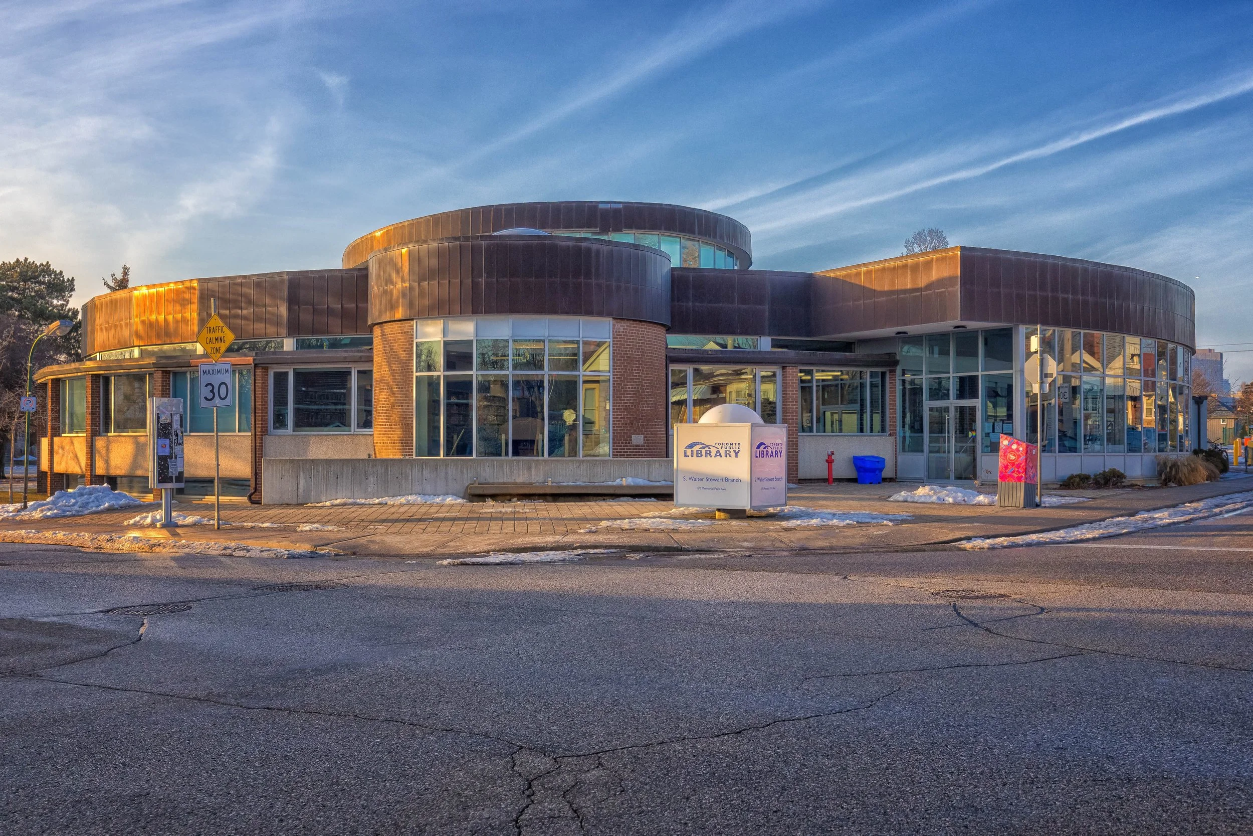 Wide exterior view of S. Walter Stewart Public Library with rounded brick architecture in East York, Toronto