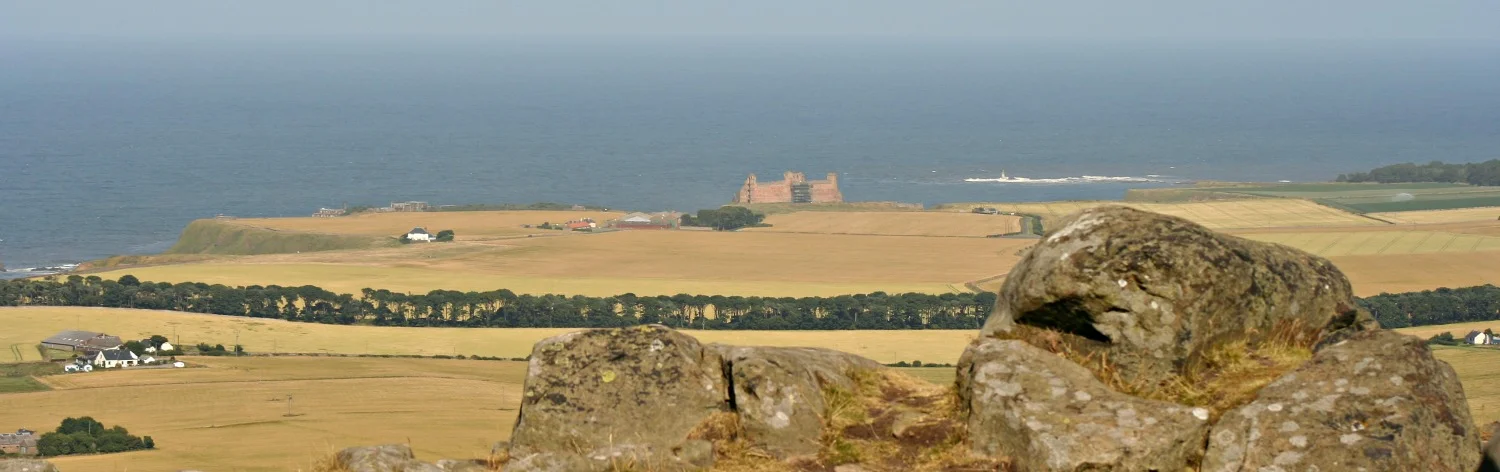 Tantallon Castle, distantly, on the coast, centre, from the top of the Berwick Law