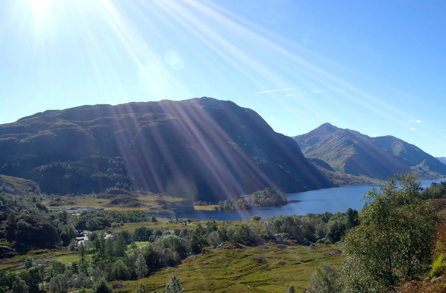 Looking south, down Loch Shiel, into the sun. Glenfinnan Monument is left of centre. Note this picture was taken on the 1st day of October. Yes, as late in the year as that and the midges that day were still horrendous .