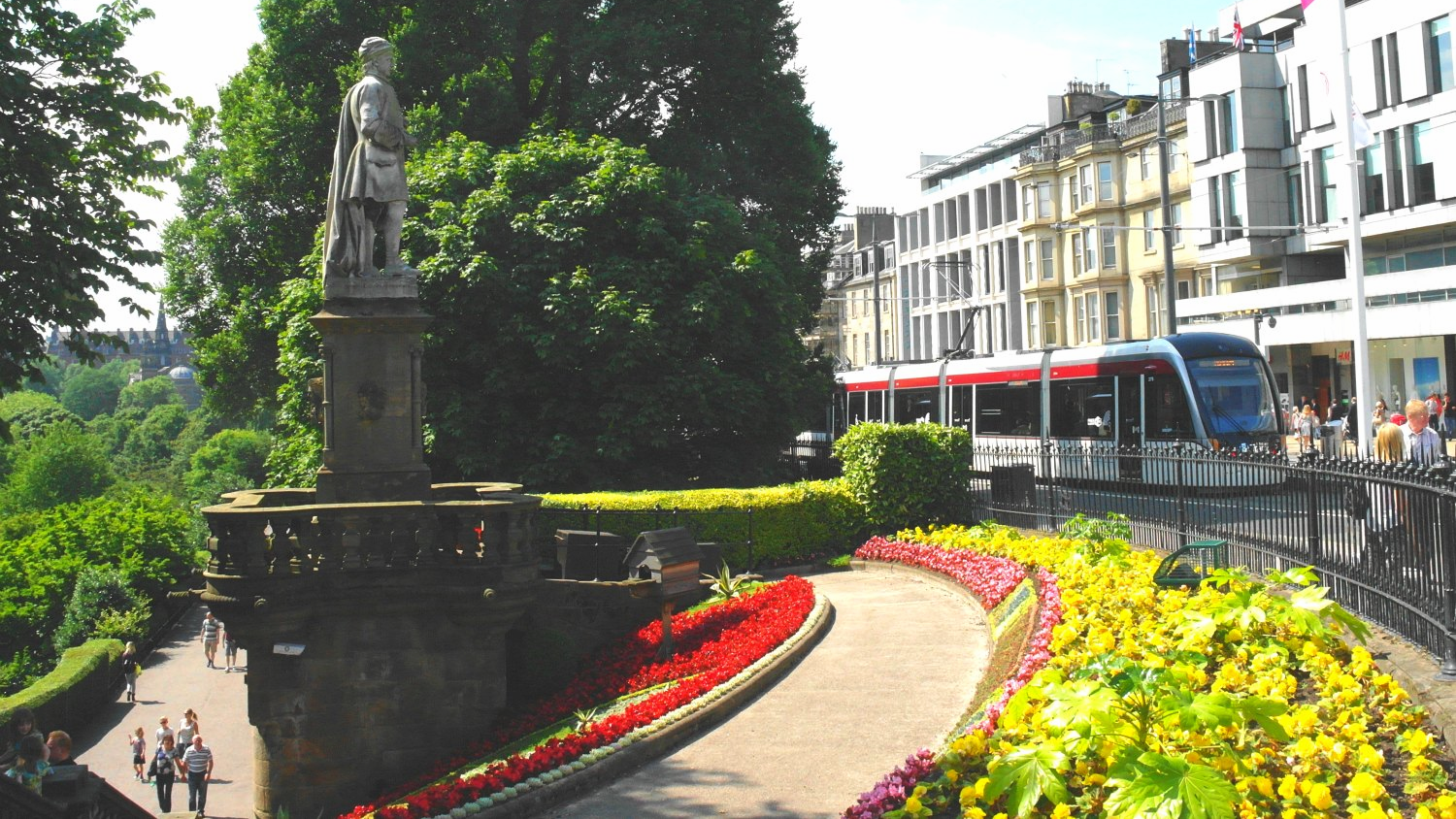 The poet Allan Ramsay's statue looks out from Edinburgh's Princes Street Gardens on the tram service that links city centre and airport.