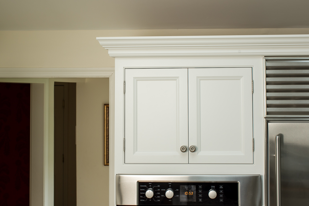 白色嵌入式橱柜，带不锈钢烤箱和壁炉