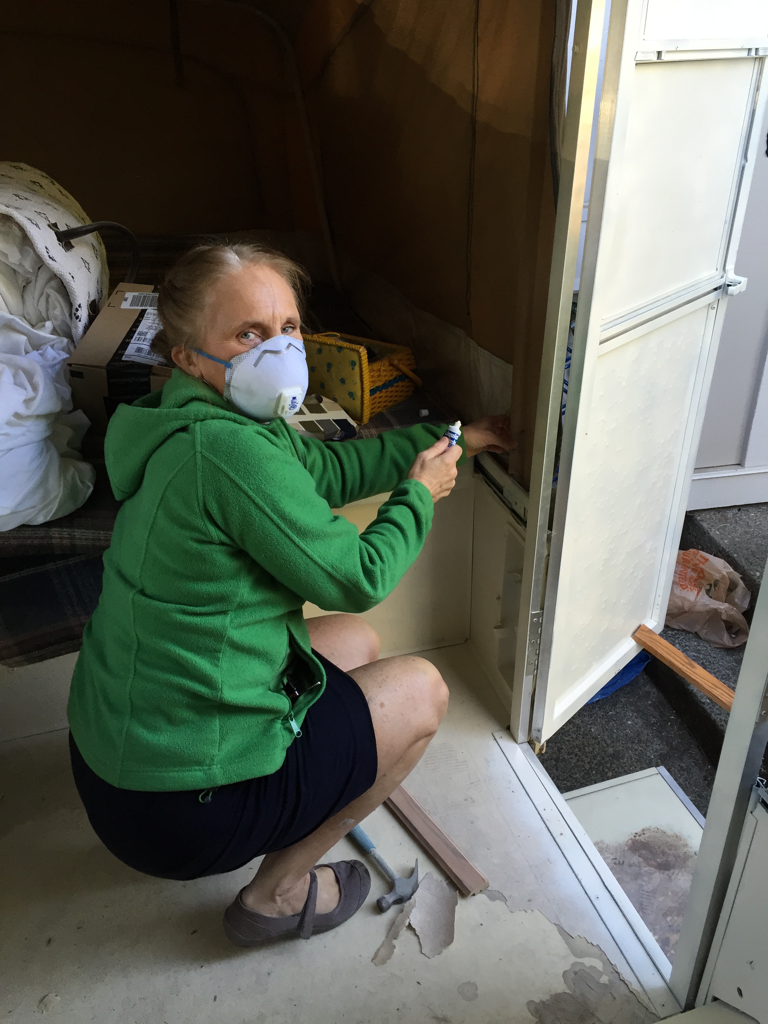 This is my mom, dressed in her church clothes and sewing patches onto the canvas of my tent trailer while I painted the cabinets.