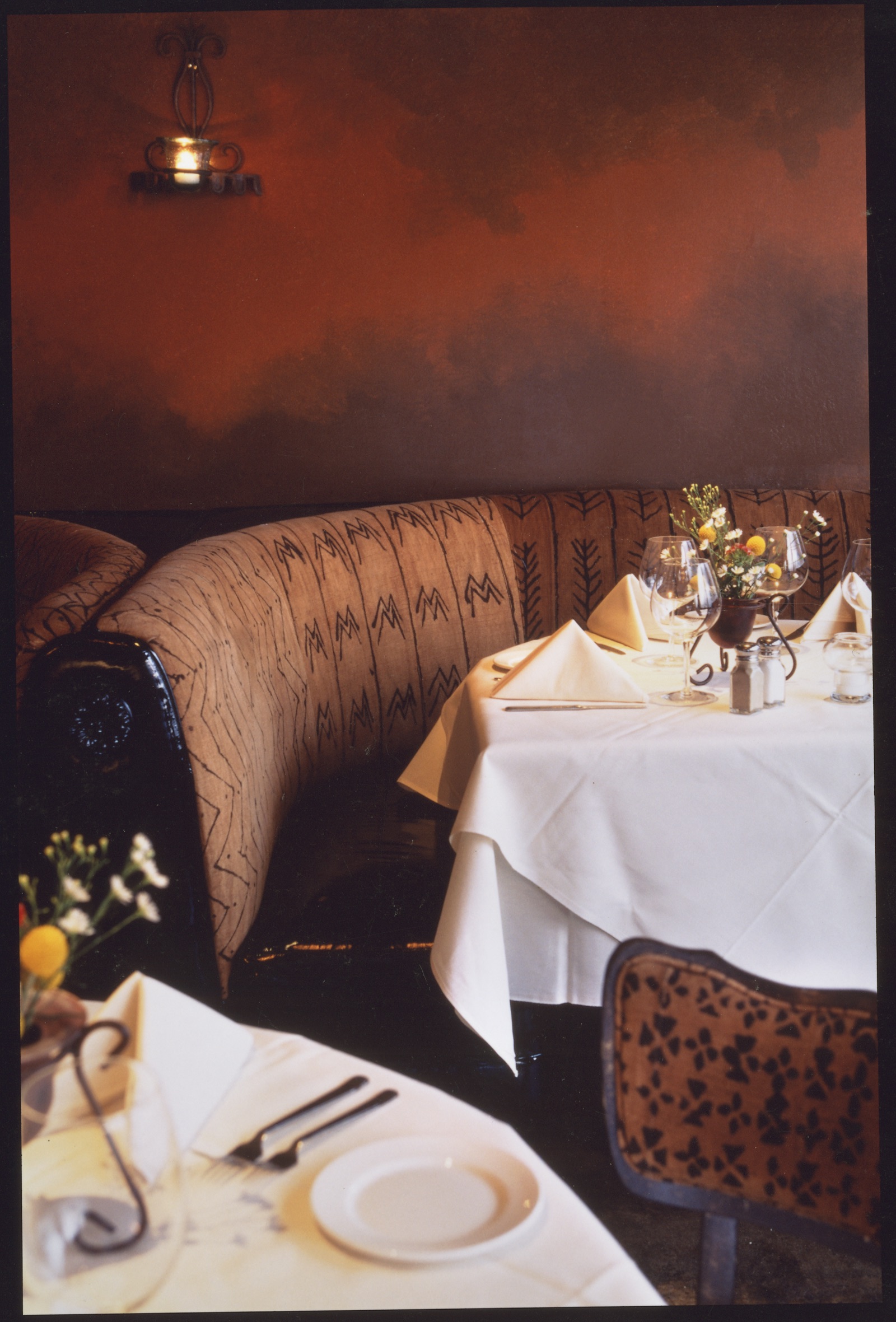 banquettes and side chairs were upholstered in african mudcloth with patent leather seats, the backs of the chairs were grass cloth upholstery with stained and glazed side chairs