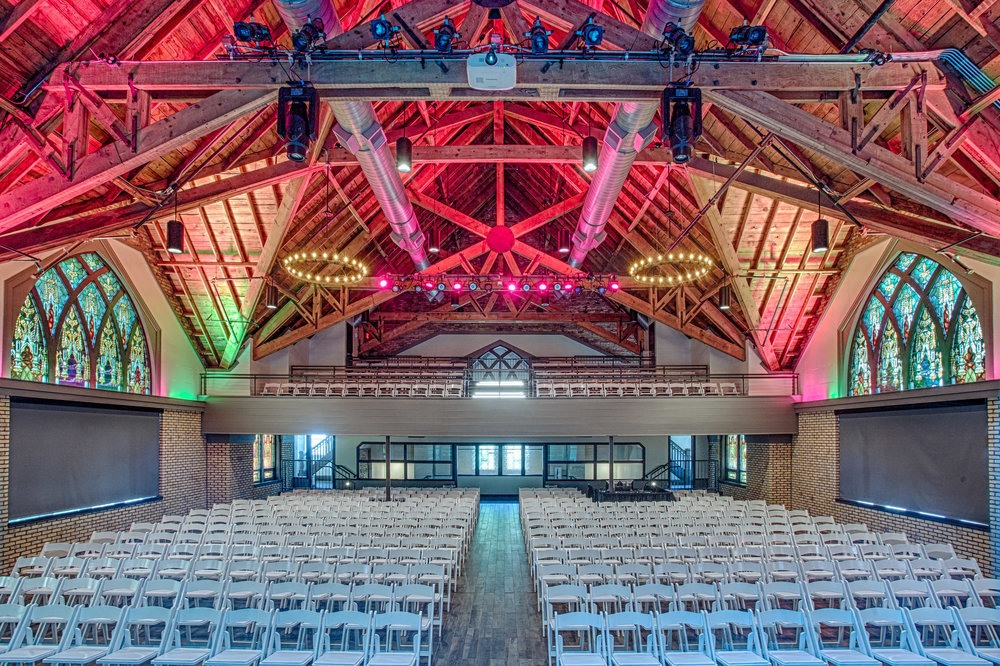 Sanctuary Event Center shows the inside, with stain glass windows, and lights bouncing off the walls.