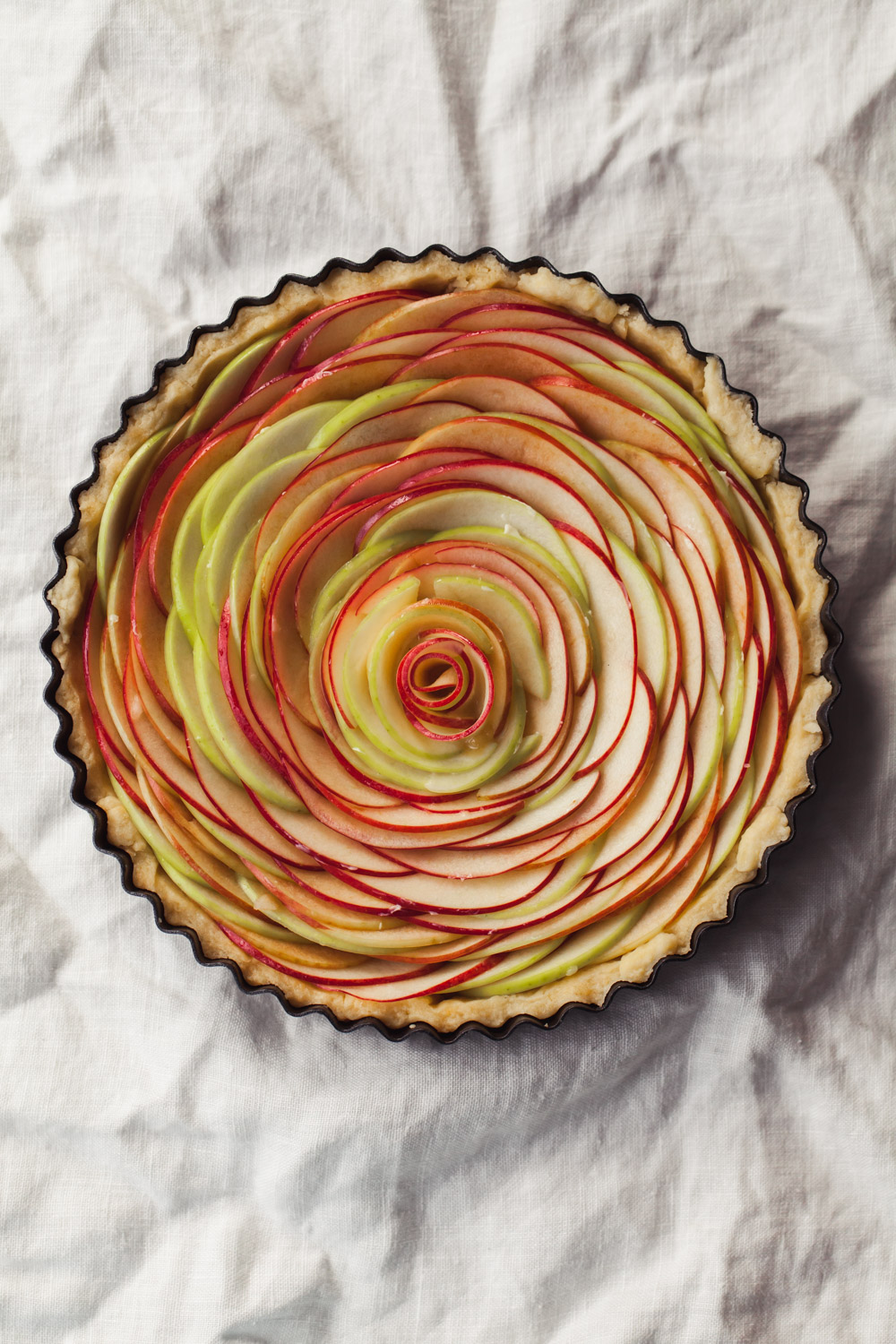 Apple slices are fanned in an unbaked tart to form a rose.
