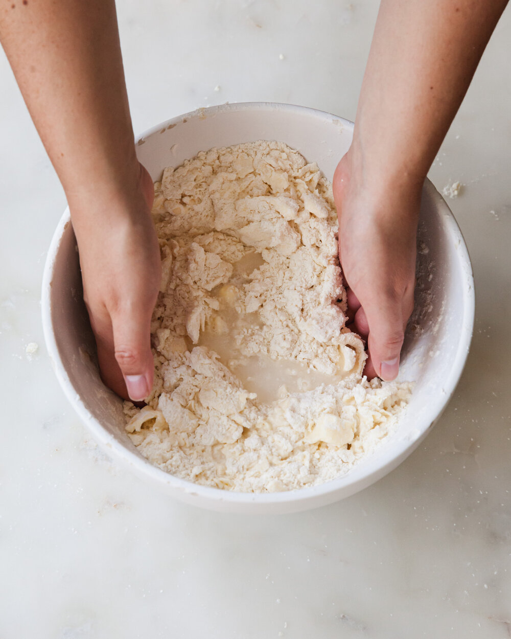 Create a well in the center of the mixture and add 6 tablespoons* of ice water.