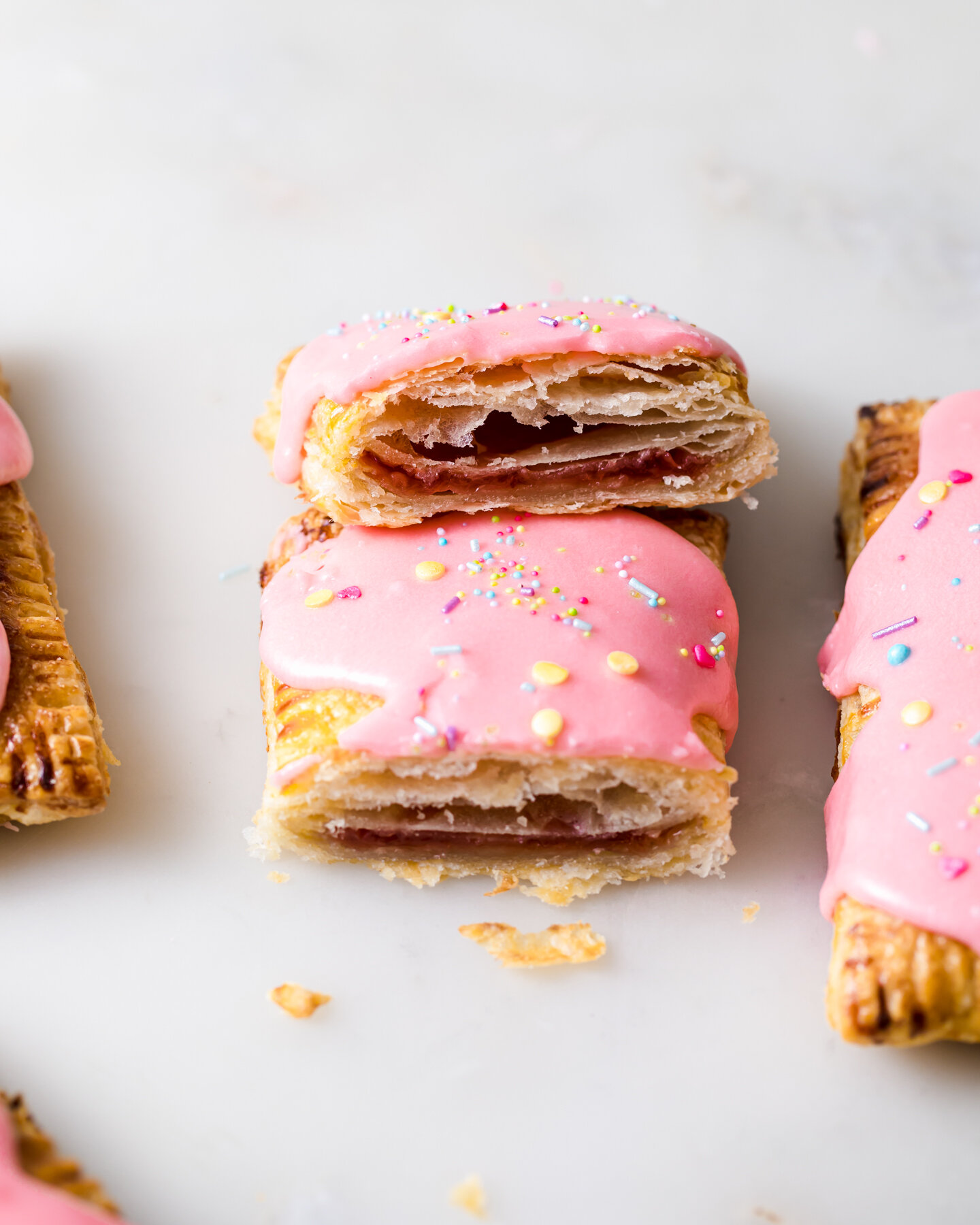 An inside look at the flaky layers  and strawberry jam filling of Homemade Strawberry Pop Tarts
