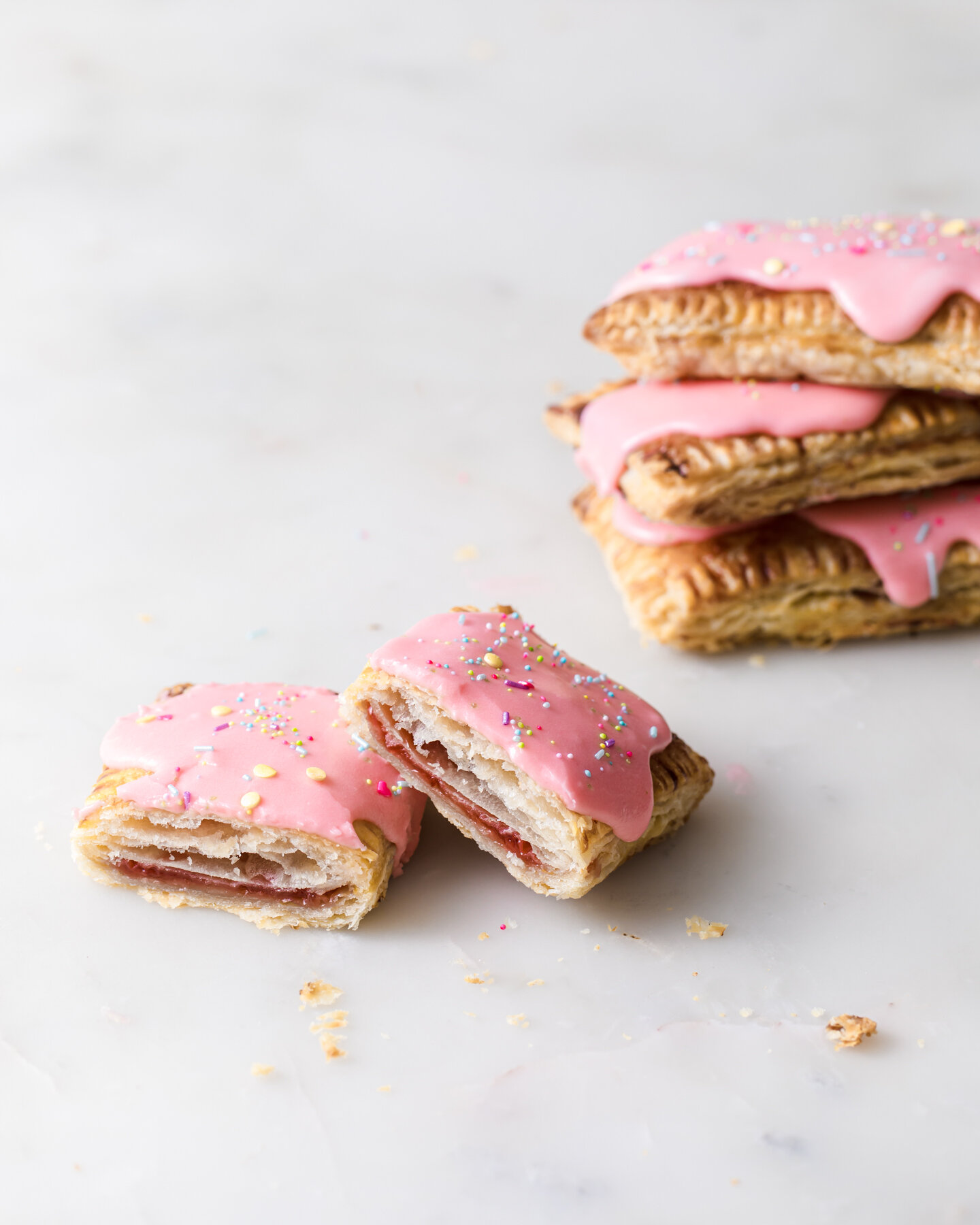 A stack of homemade strawberry pop tarts wtih flaky crust and jam center.