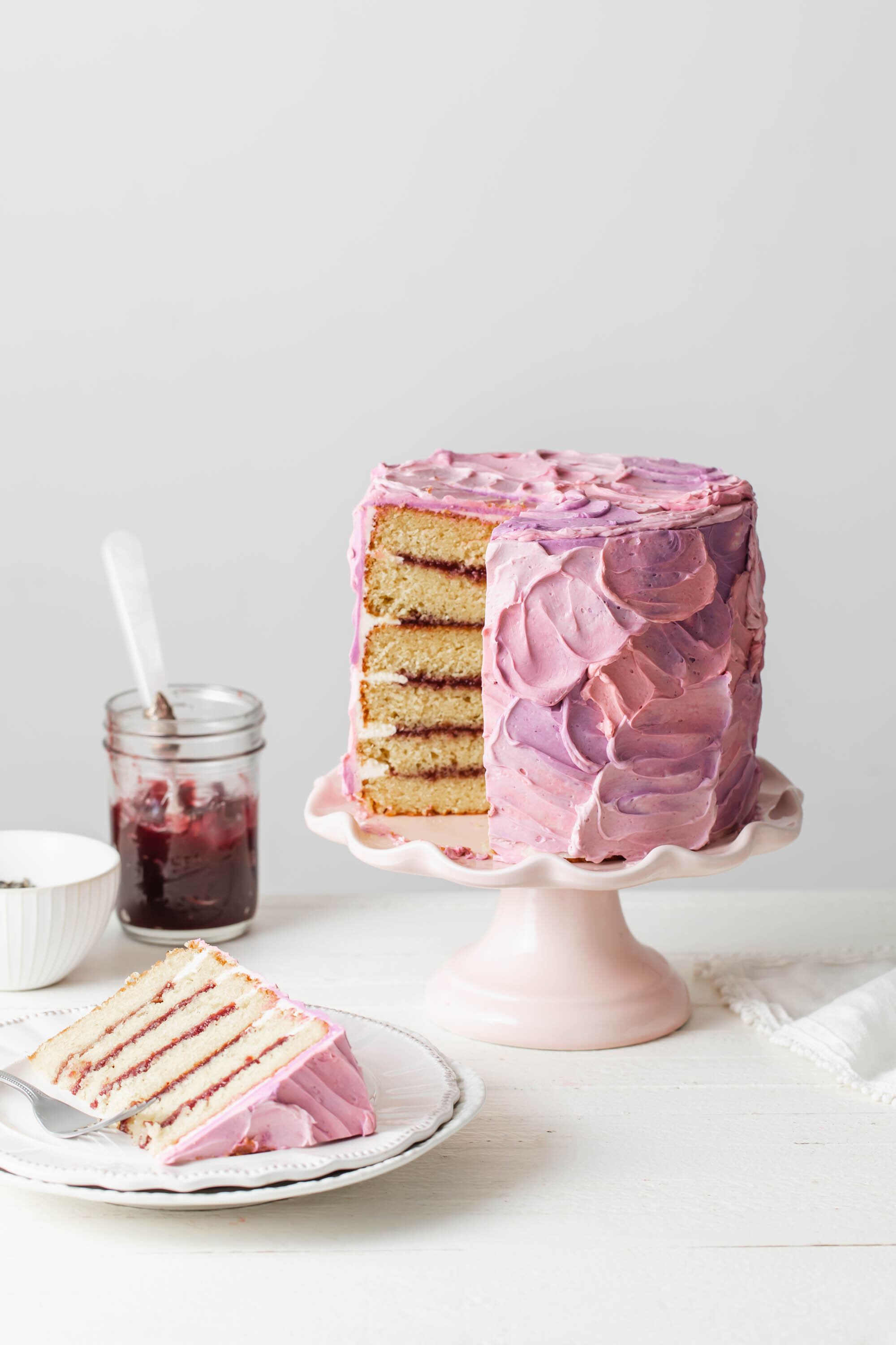 A 6-inch lavender cake with blackberry filling that is frosted with pink and purple Swiss meringue buttercream