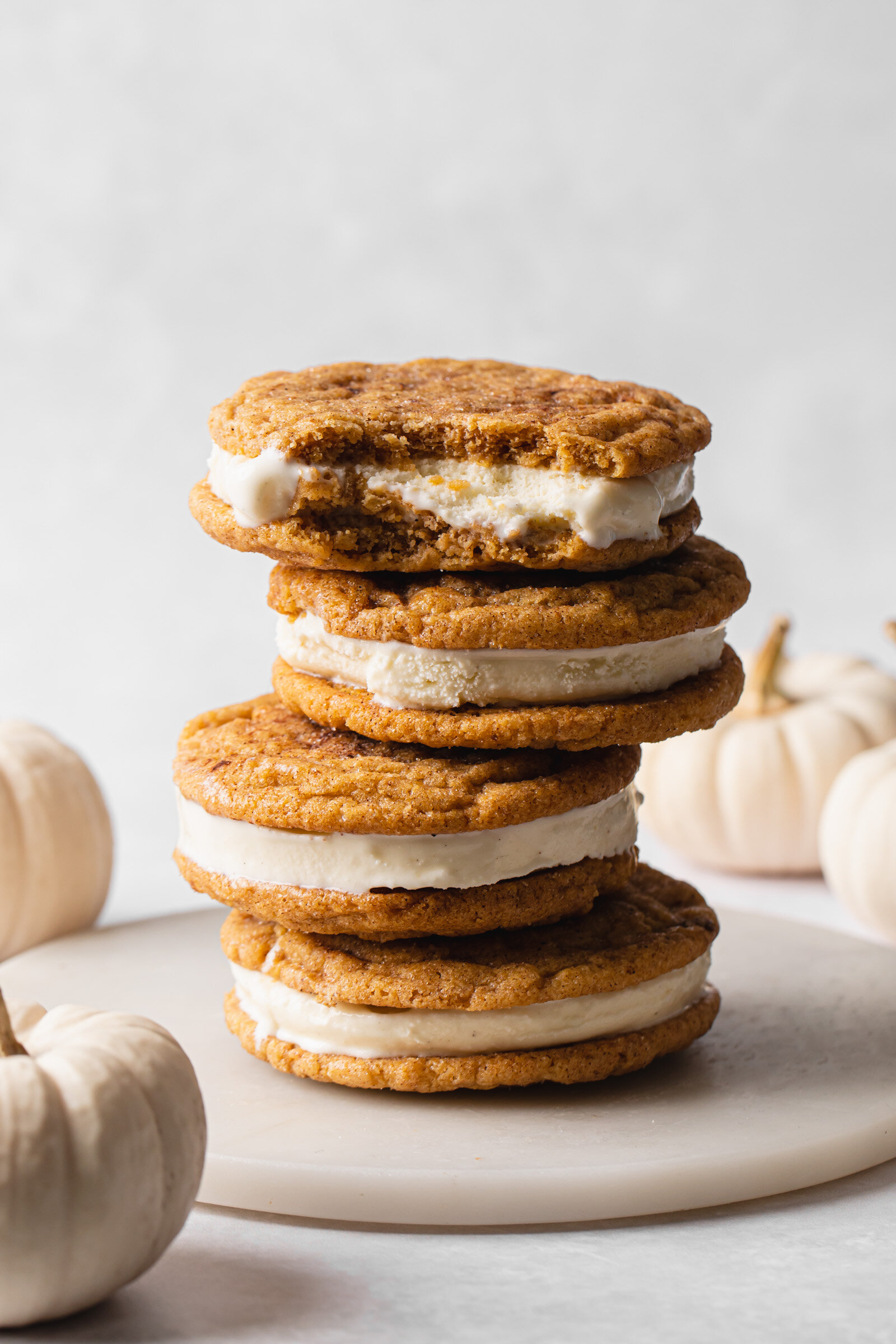 A towering stack of Pumpkin Snickerdoodle Cookies with vanilla ice cream in between.