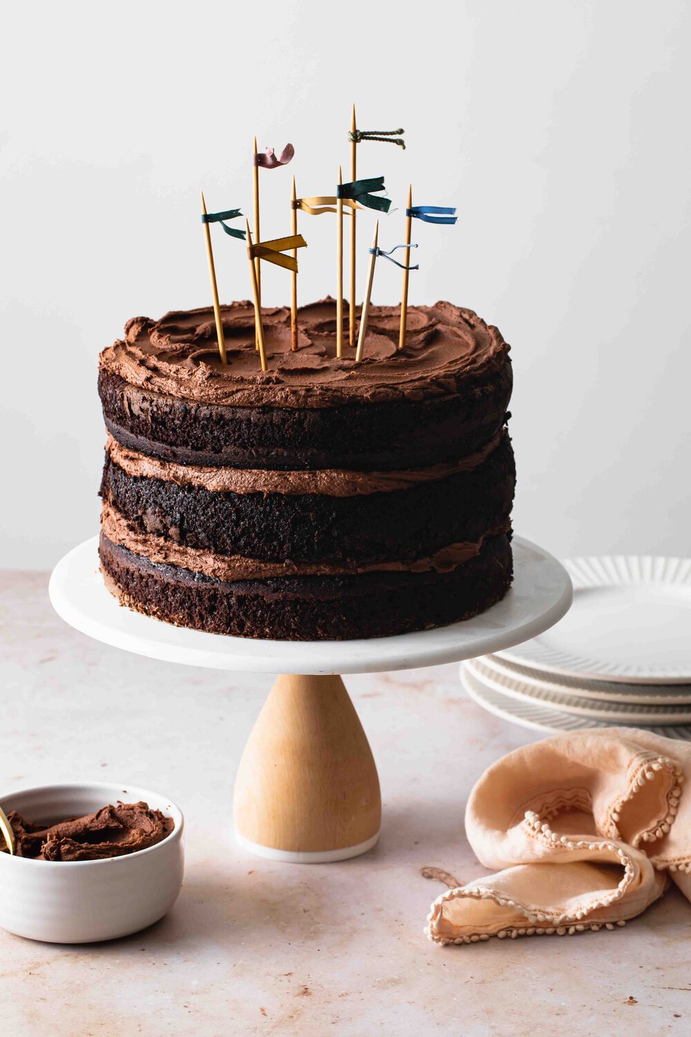 A 3-layer chocolate cake with fluffy fudge frosting swirled on top.