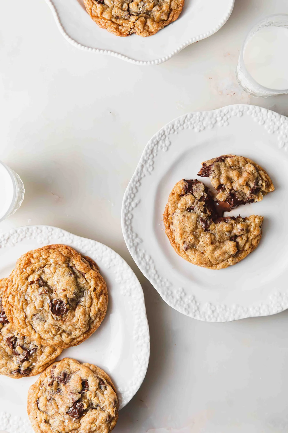 Oatmeal Nutella Stuffed Cookies on white plates with melted chocolate oozing out.