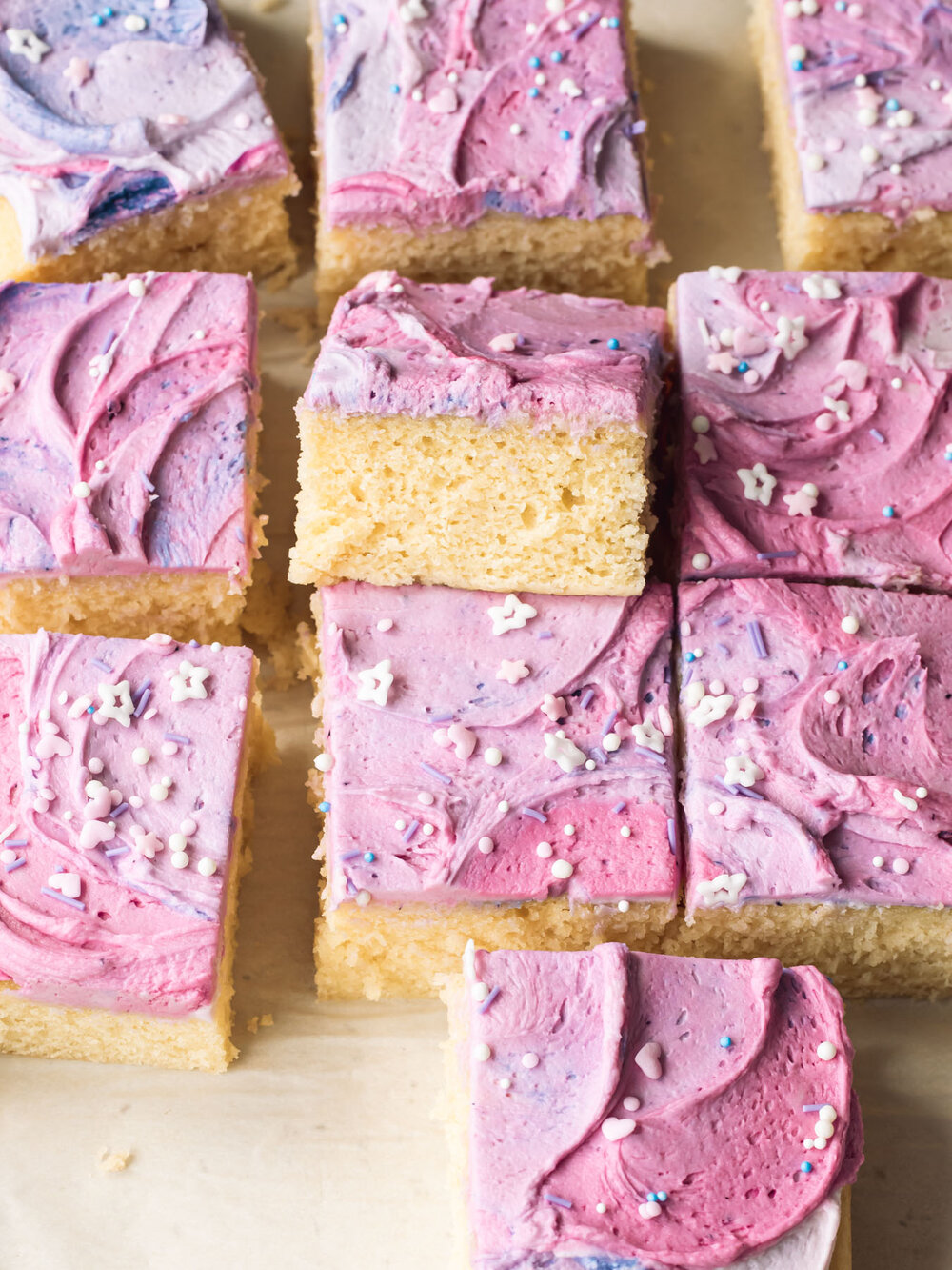 A vanilla sheet cut sliced into squares and frosted with whipped buttercream.
